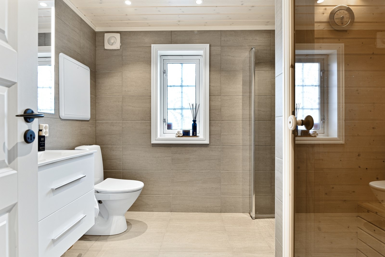 Baderomsgulvet er belagt med keramiske fliser. Veggene er belagt med keramiske fliser. Panel i himlingen. Innfelte downlights. Galleribilde