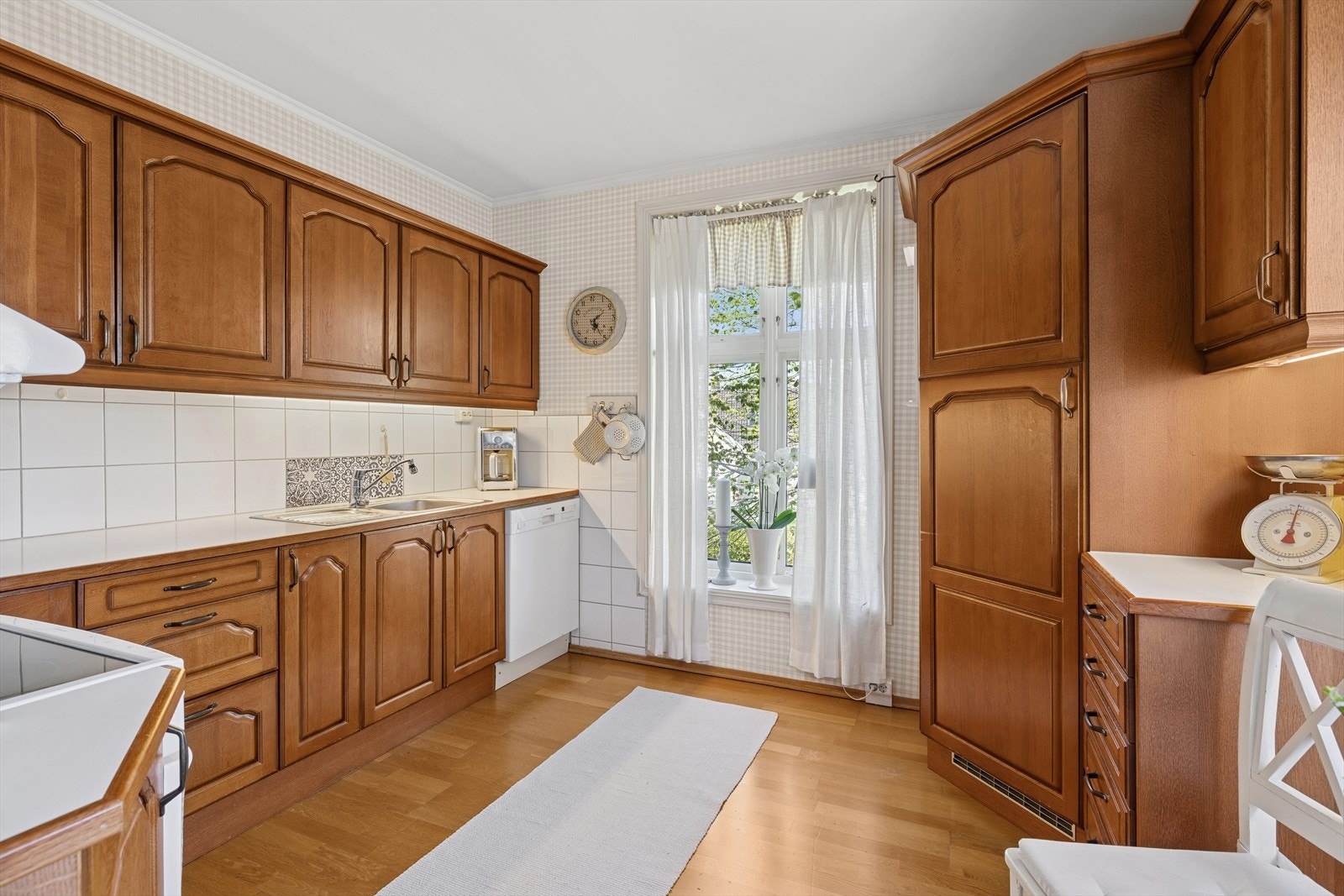 Lyst og hyggelig kjøkken med godt med både benk- og oppbevaringsplass Galleribilde