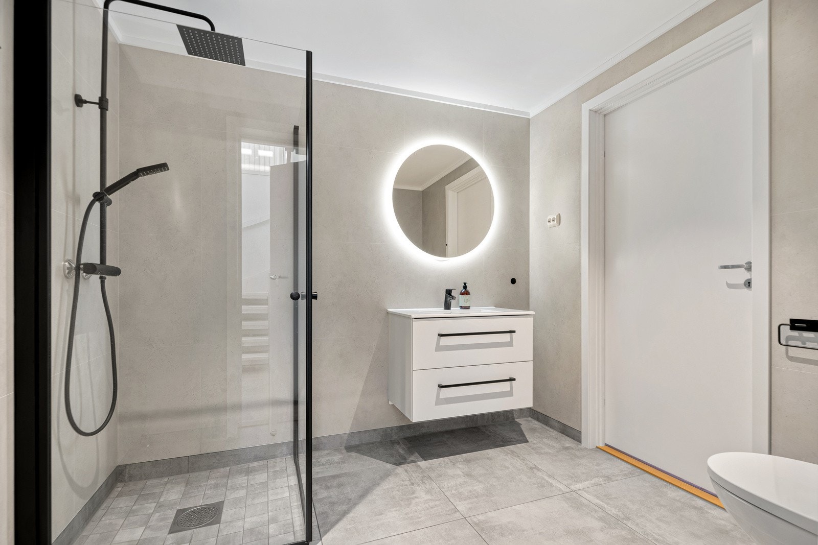 Pent og moderne baderom med servant, dusjhjørne og vegghengt toalett. Galleribilde