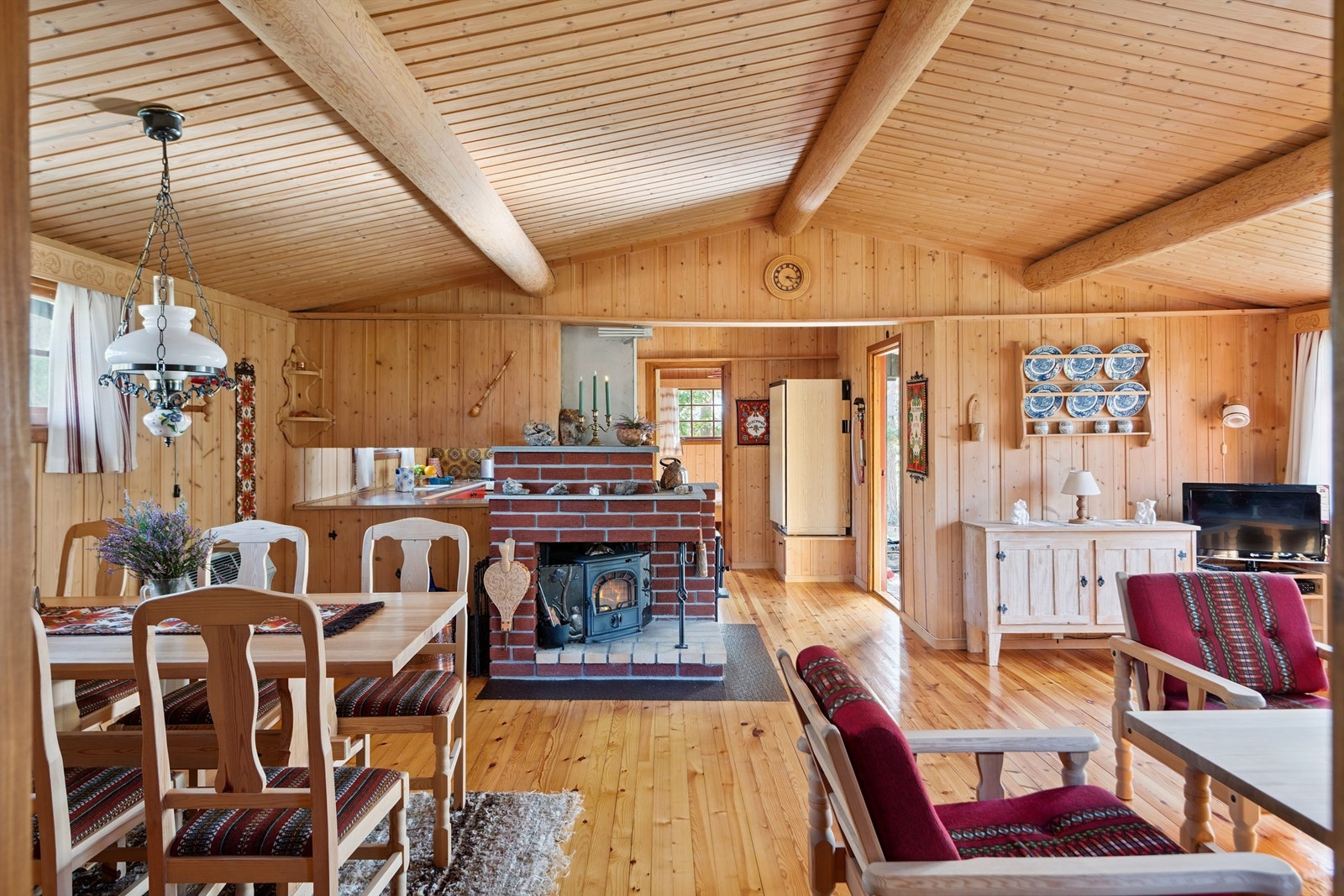Stuens midtpunkt er den åpne peiskonstruksjonen med vedovn. Galleribilde