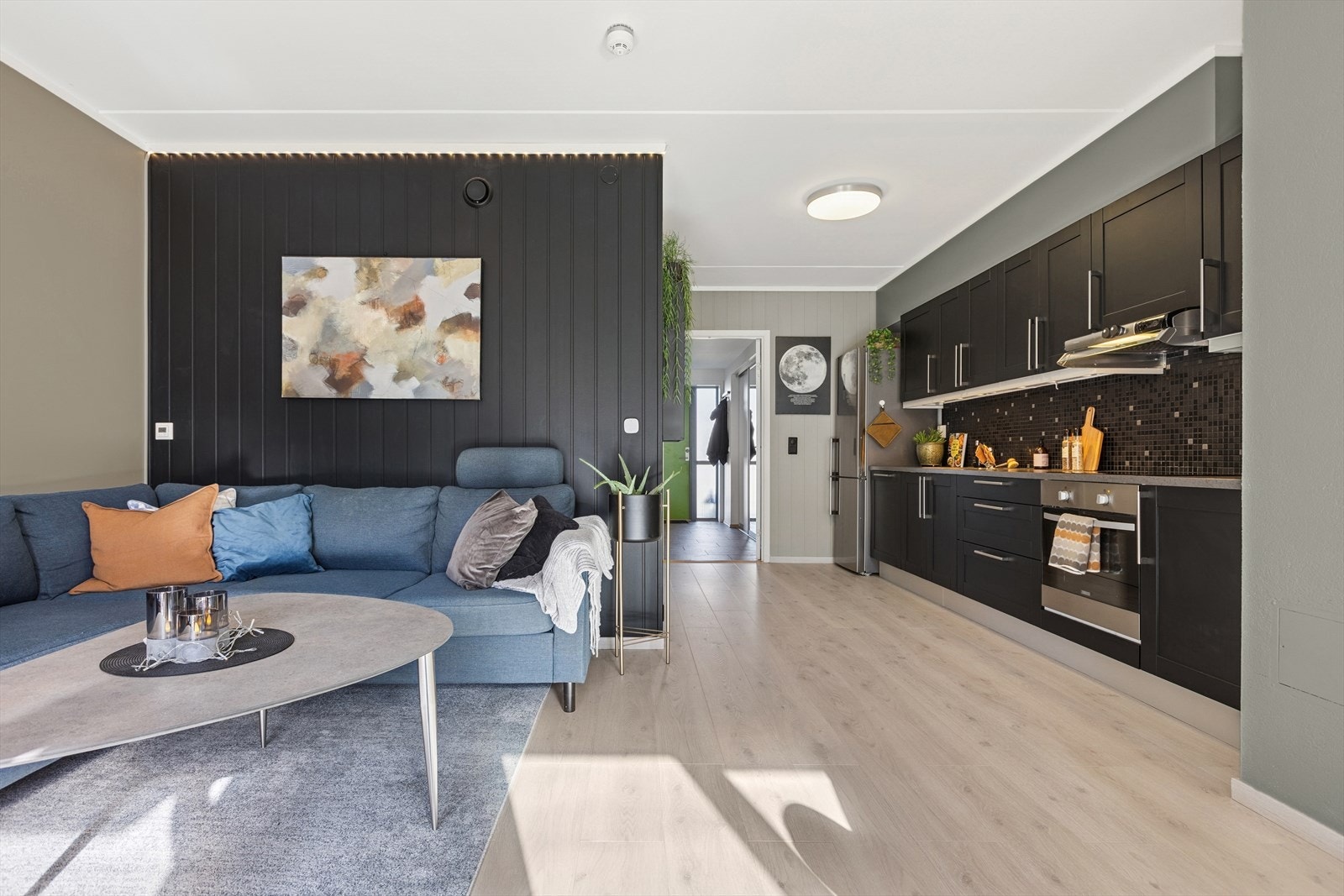 Leiligheten har en moderne og åpen stue- og kjøkkenløsning med god plass til både sofagruppe og spisebord, noe som gir en sosial og funksjonell romfølelse. Galleribilde
