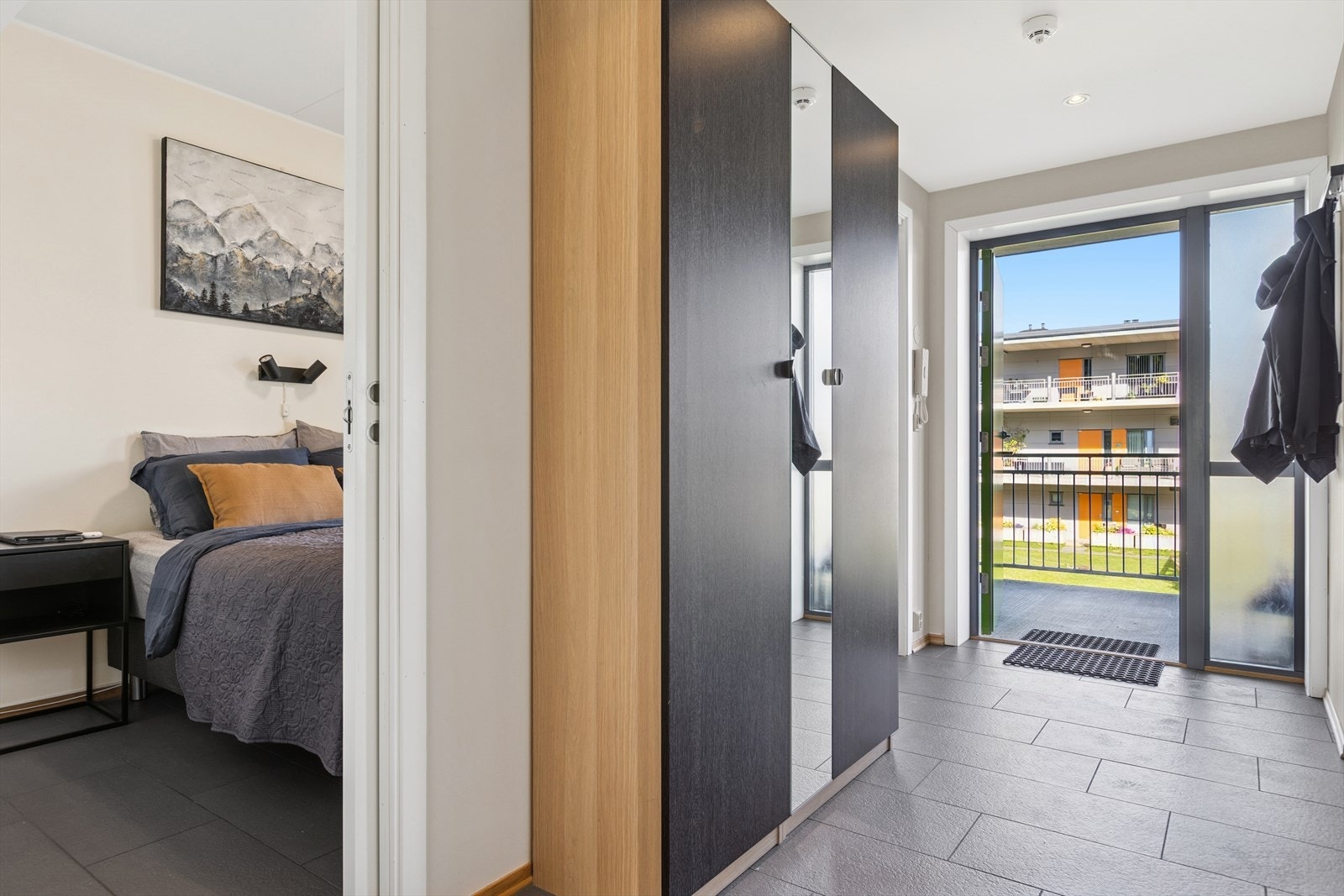 Entreen som ønsker deg velkommen inn har plass til å henge fra seg yttertøy og plassere fottøy. Det er i tillegg god plass til oppbevaring i et praktisk skyvedørsgarderobe. Galleribilde