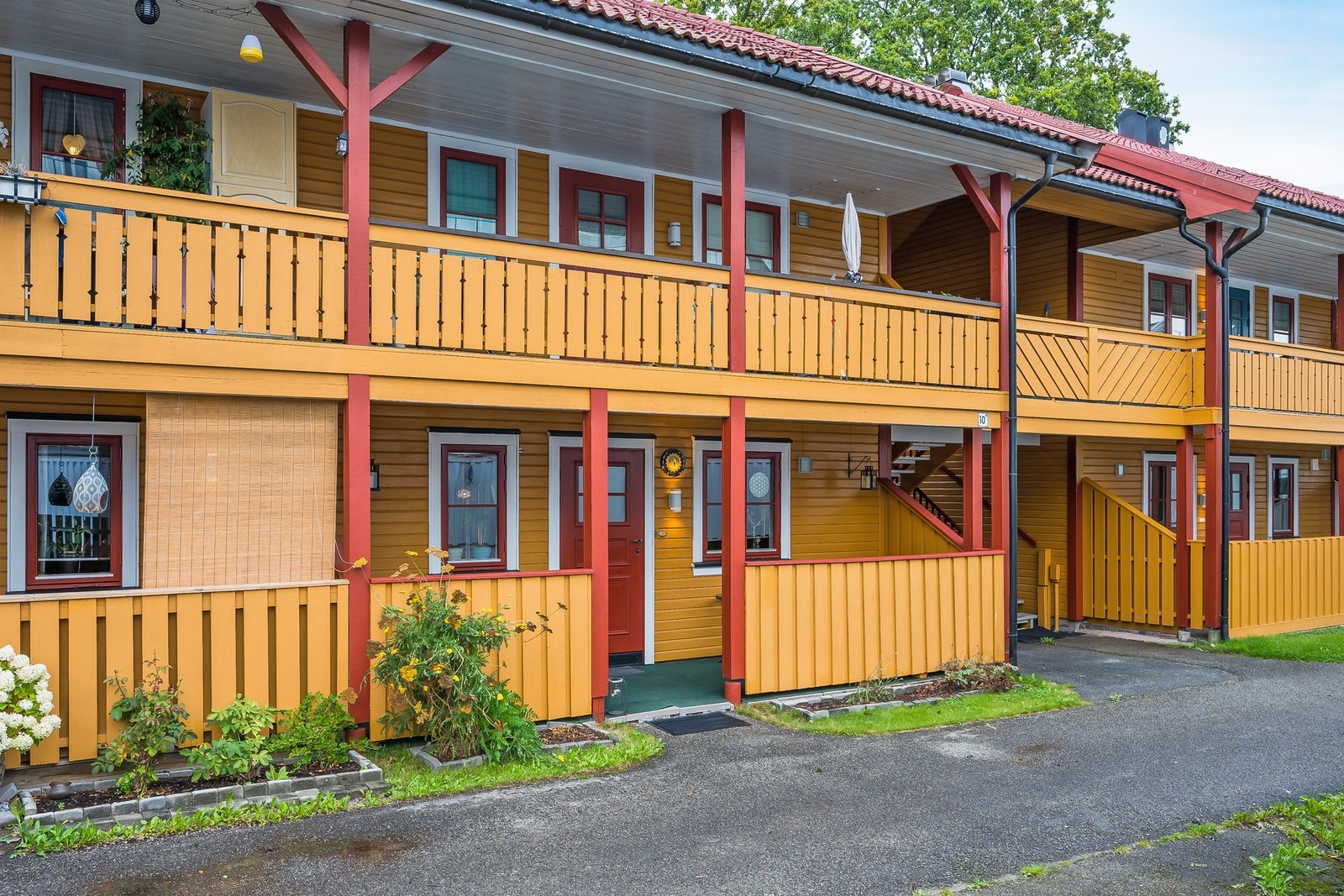 Her ser vi fasaden mot vest - leiligheten ligger "midt i bildet" med hvit parasoll Galleribilde