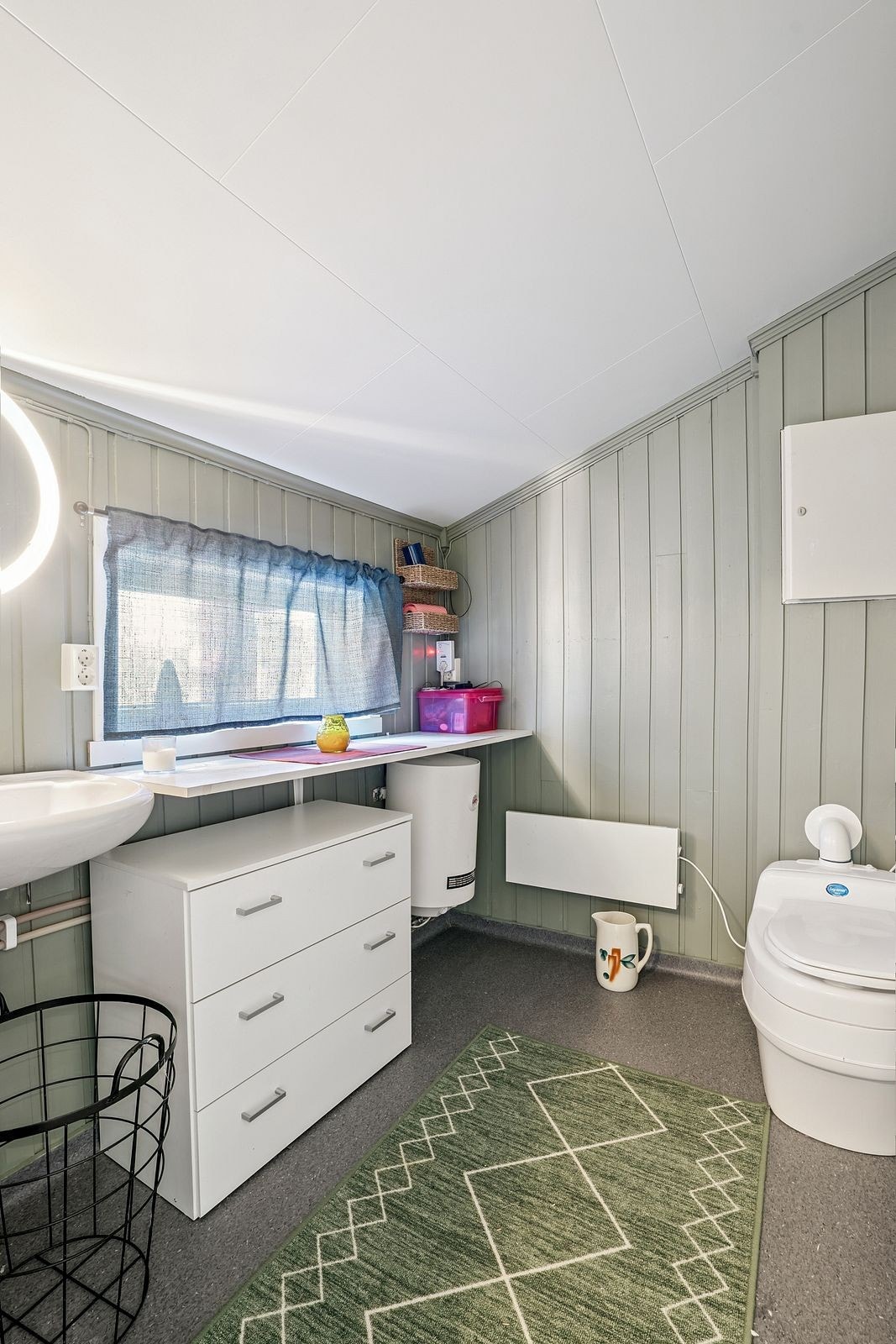 Toalettrommet er på tegningen betegnet som bod. Her er det servant med vann fra vanntank som står ute. Varmtvannsbereder og toalettløsningen er Separett. Galleribilde