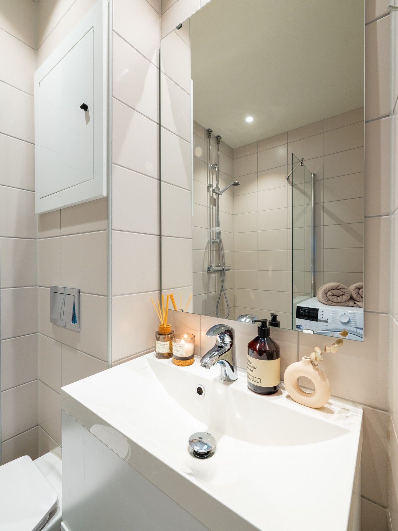 Badet er utstyrt med baderomsinnredning med slette fronter og ovenpåliggende servant, samt speil over. Galleribilde
