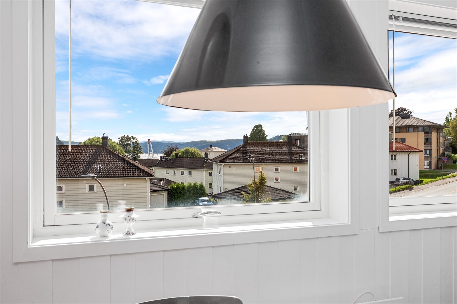 Utsikt fra stue mot syd med glimt av sjøen Galleribilde