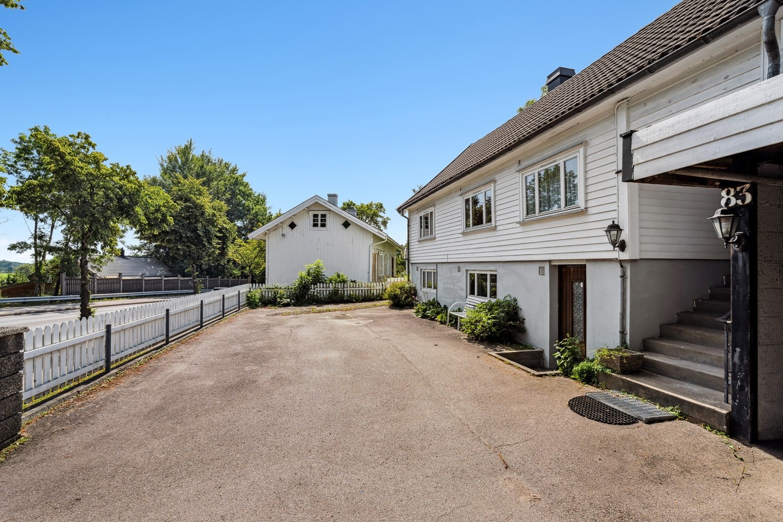 Tomten er romslig og har et variert uttrykk med stor asfaltert gårdsplass. Galleribilde