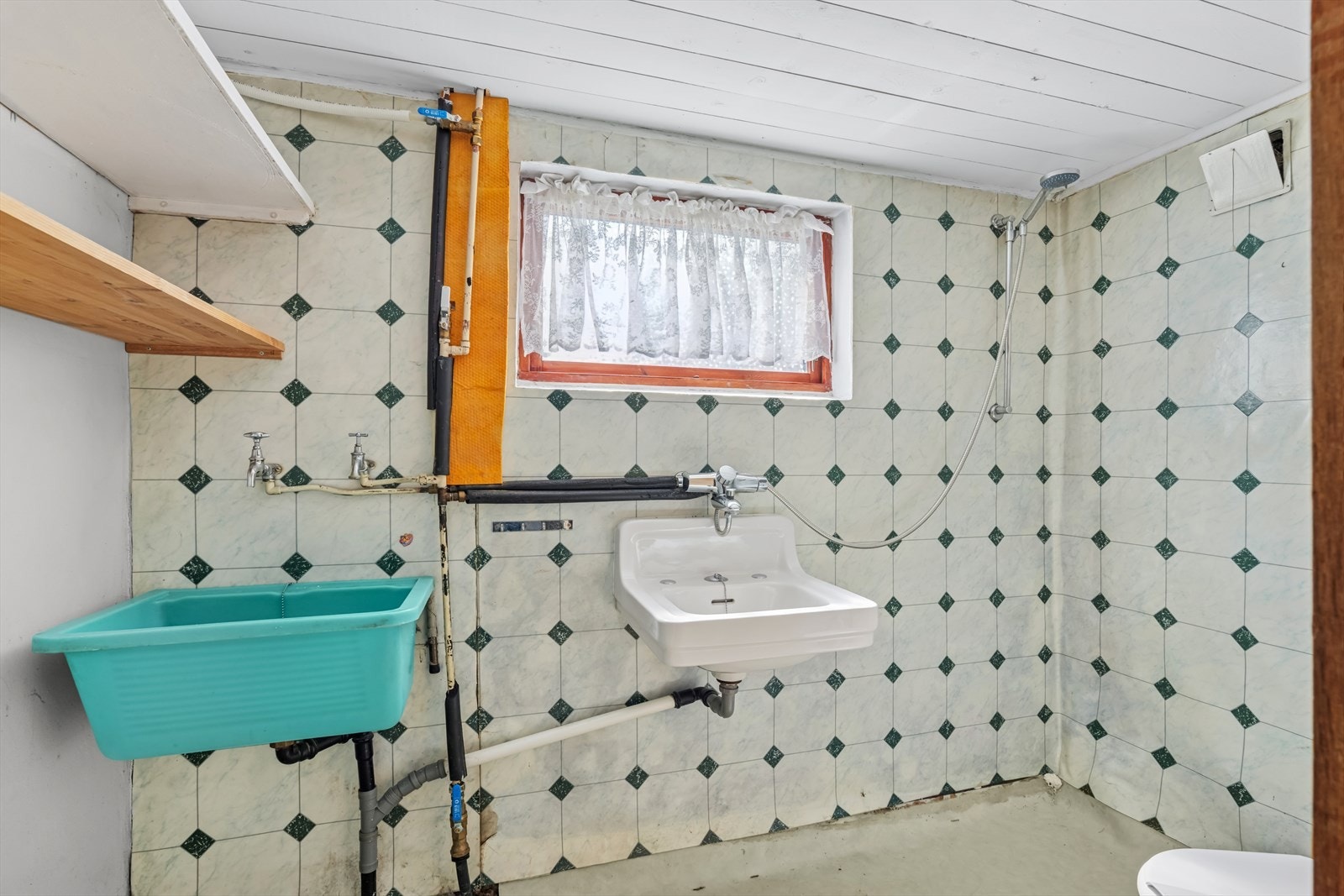 Baderommet fremstår enkelt, med innredning som inkluderer vask, toalett, dusjplass og opplegg for vaskemaskin. Galleribilde