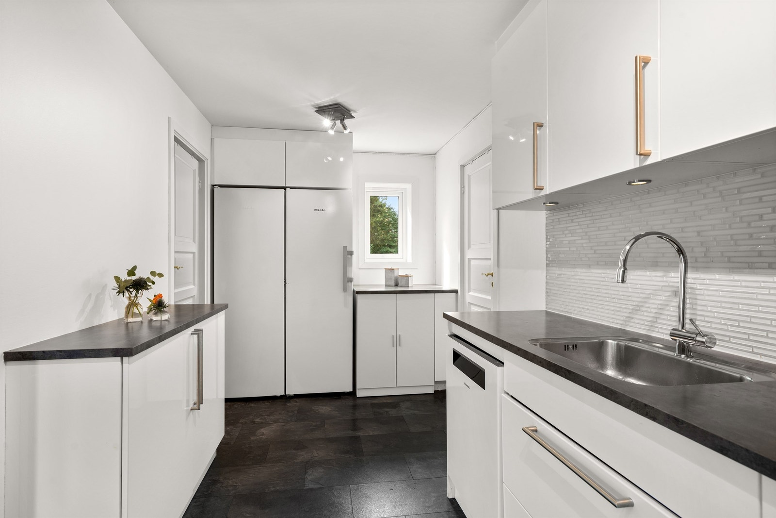 Opprennelig vaskeromsdel ved kjøkken med opplegg for vaskemaskin og tørketrommel. Galleribilde