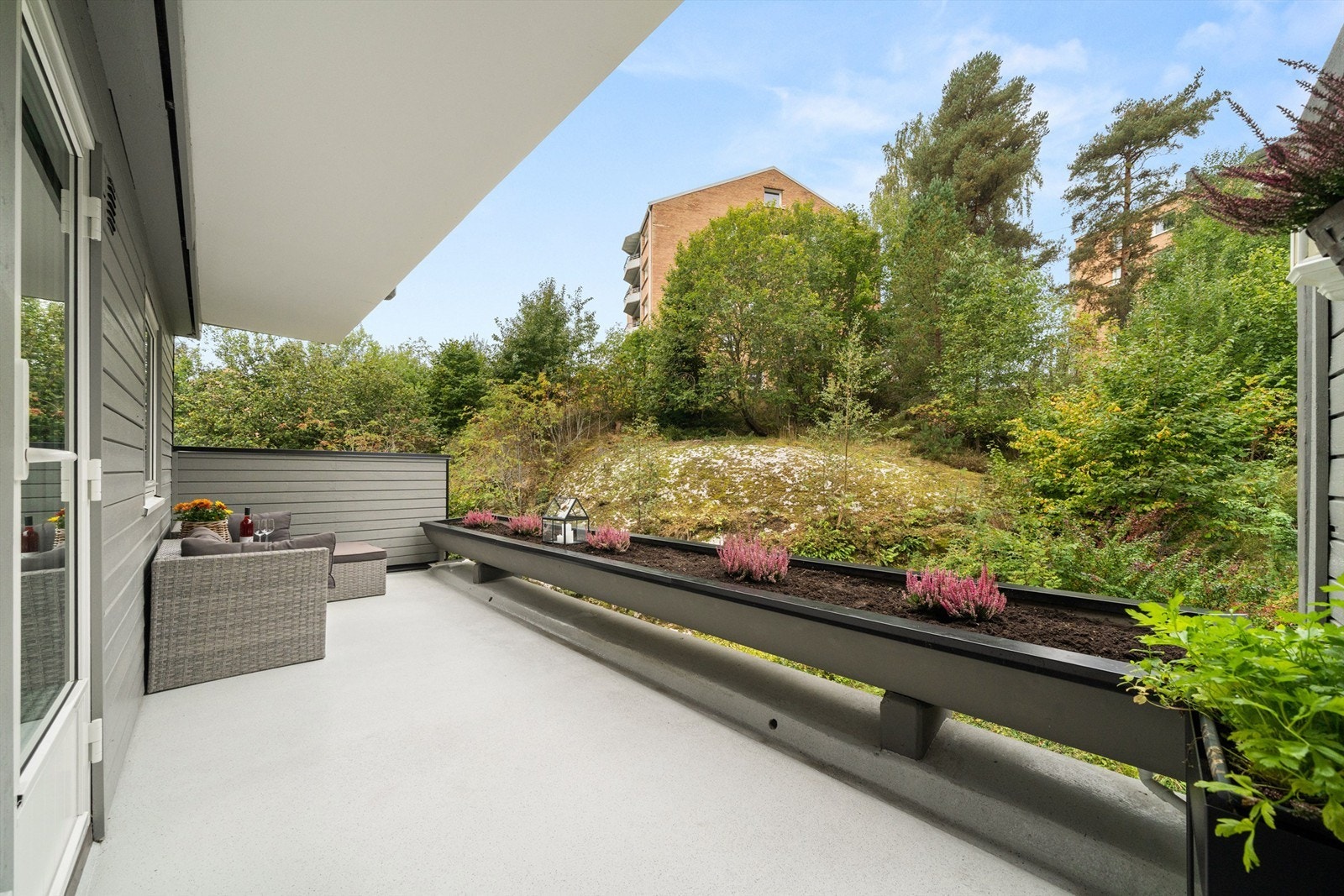 Solrik vestvendt terrasse med utsyn mot grøntområdet. Galleribilde