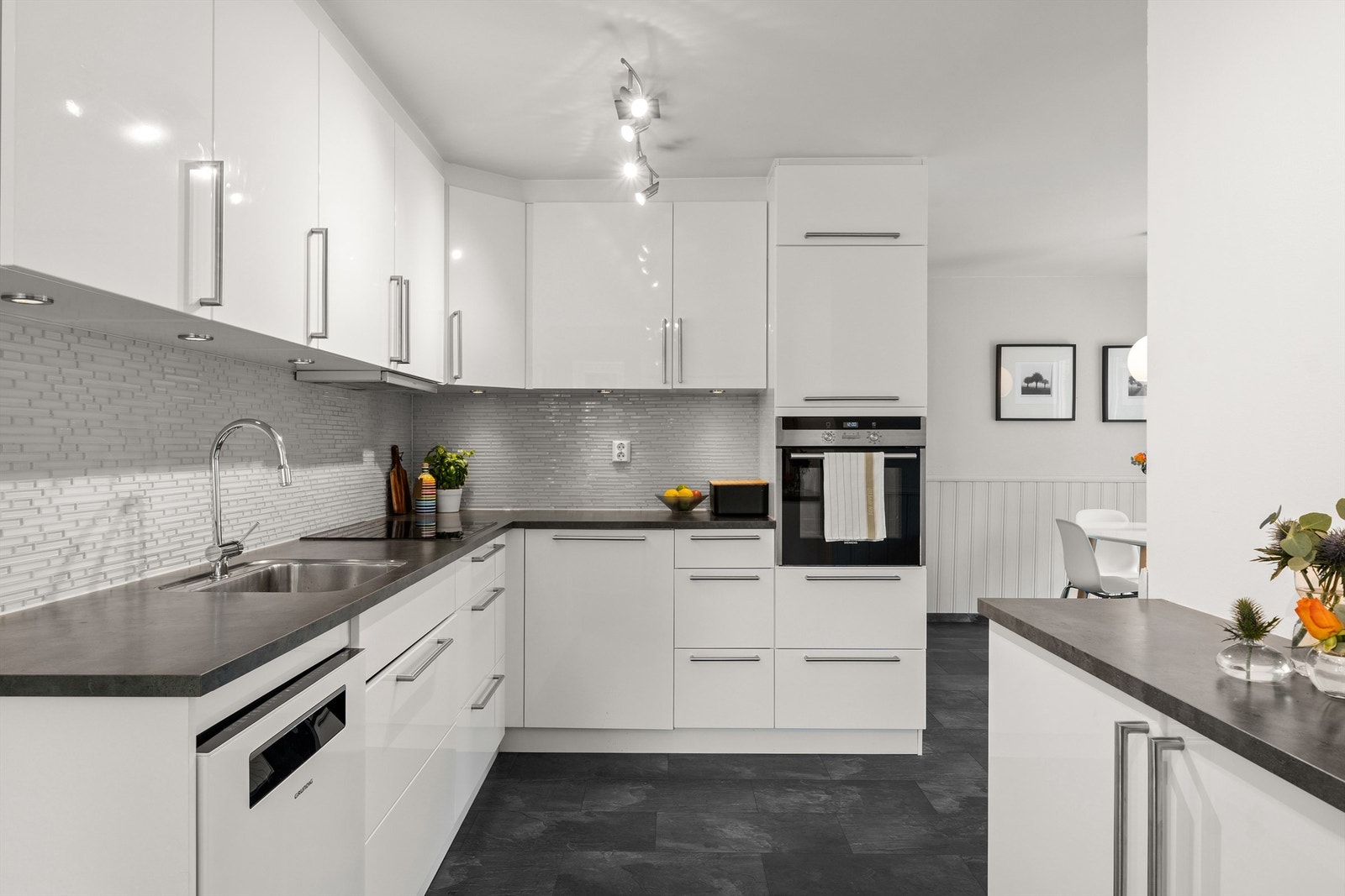 Kjøkkenet har god plass til spisebord og fungerer som et meget sosialt rom. Kjøkkeninnredning fra KVIK montert i 2012 med fronter i høyglanset utførelse. Galleribilde