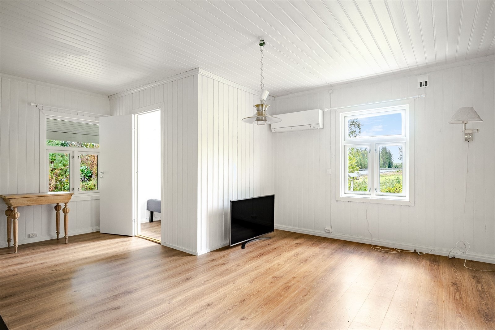 Boligen har en trivelig stue med laminatgulv og lysmalte vegger. Store vinduer gir godt med innslipp av naturlig dagslys. Galleribilde