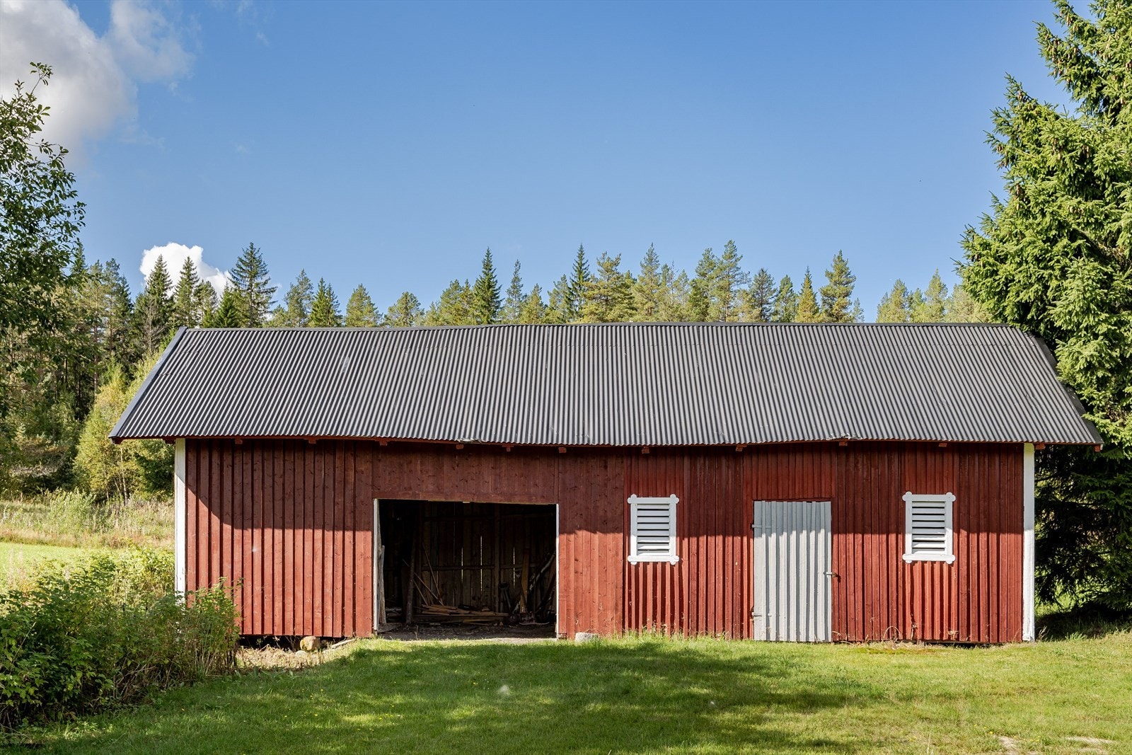 Det største uthuset har svært god lagringsplass og en stor carport. Galleribilde