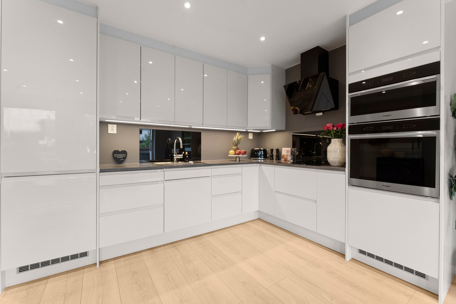 Lekkert kjøkken med tidløse, glatte fronter og benkeplate i laminat. Galleribilde