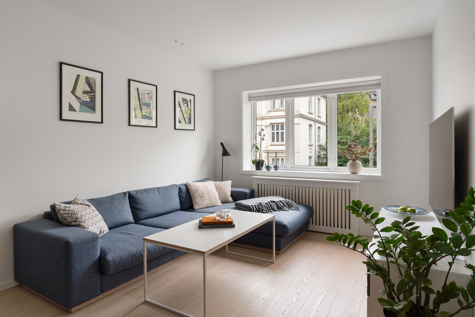 Lys stue med en stor vindusflate som bidrar til rikelig med naturlig lys. Galleribilde