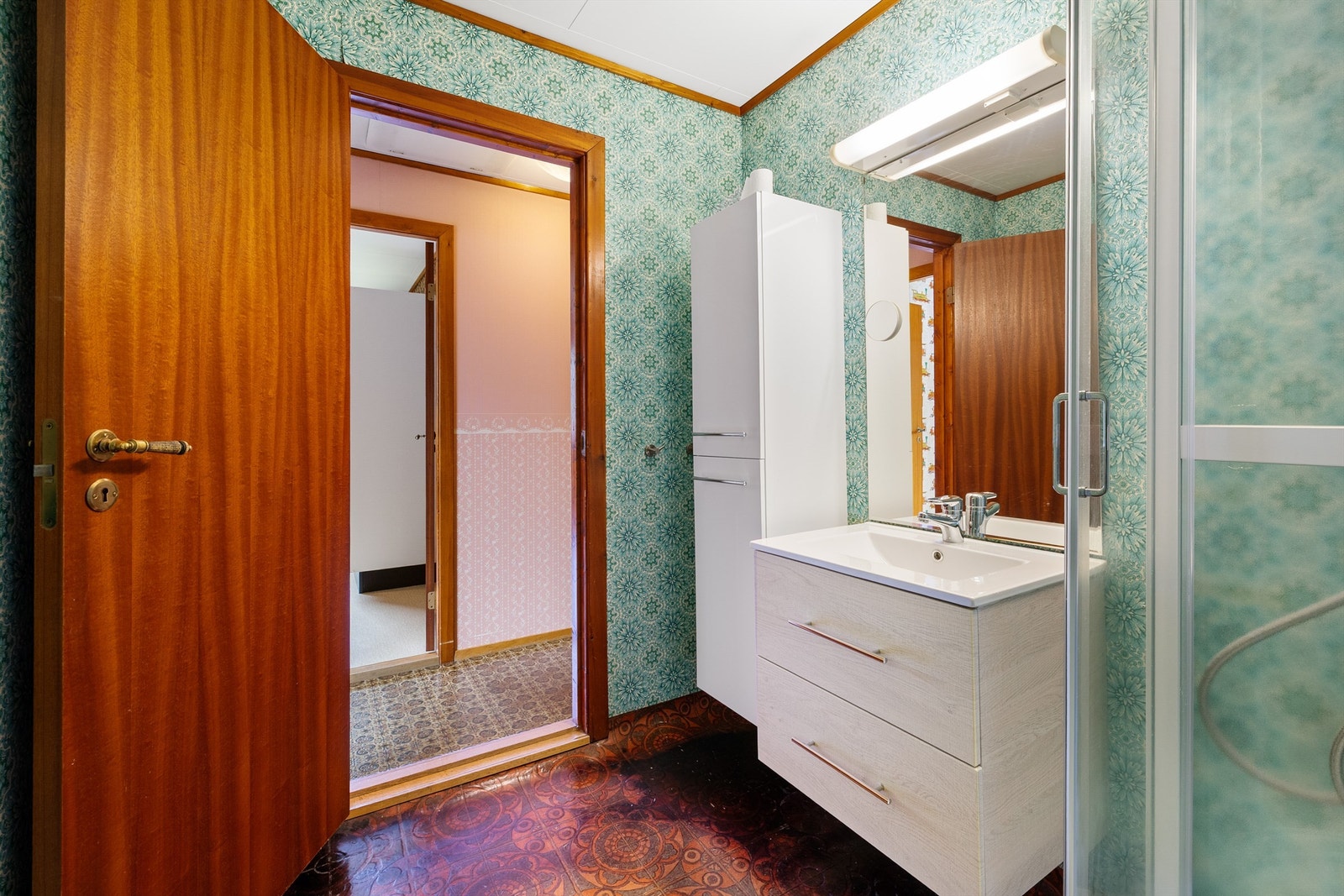 Bad innredet med baderomsinnredning m/høyskap og dusjkabinett. Galleribilde