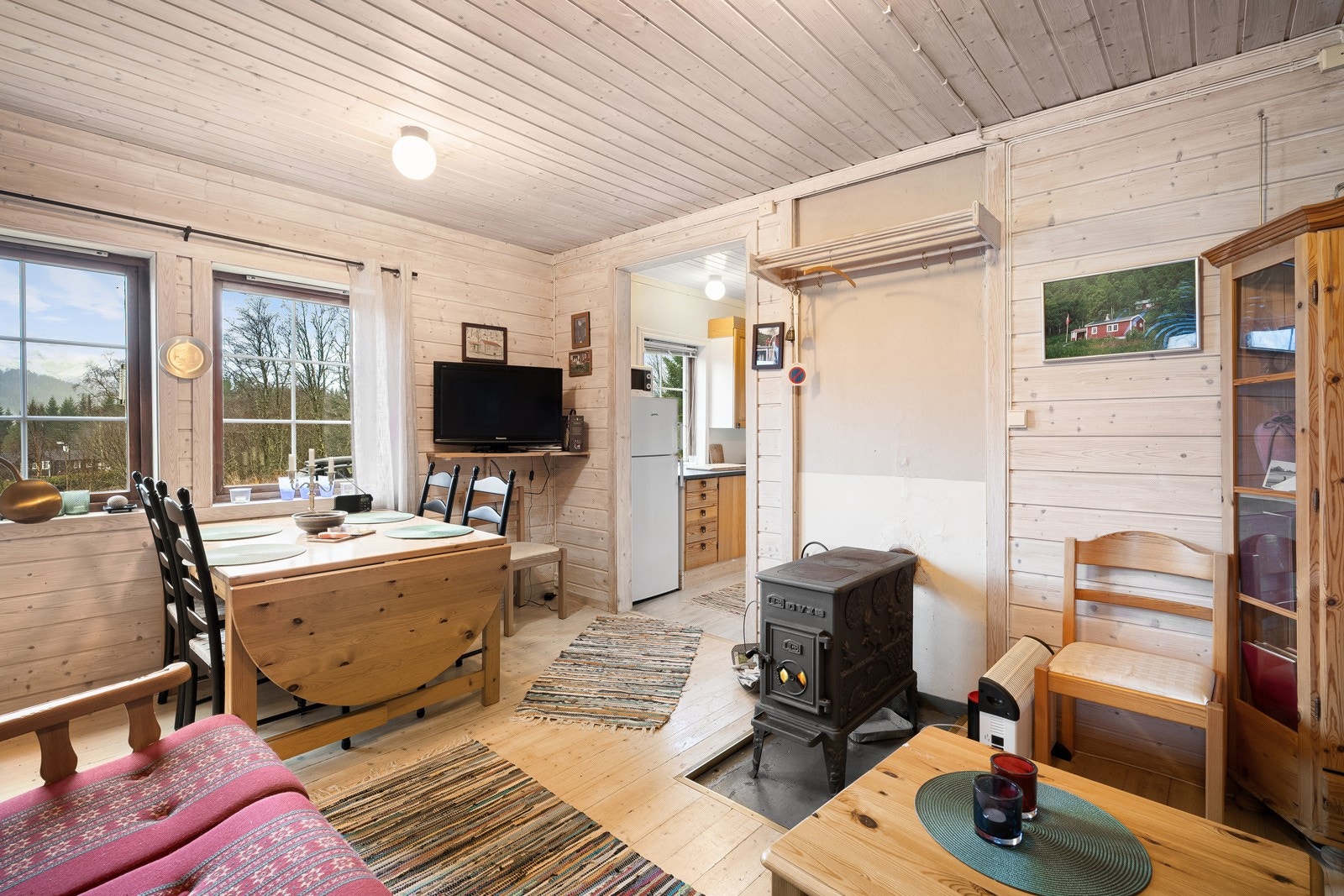 Stue med vedovn, spisebord og sofa Galleribilde