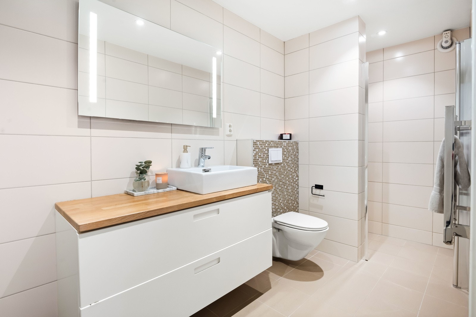 Flisalgt baderom i lyse moderne farger med opplegg for vaskemaskin og tørketrommel Galleribilde