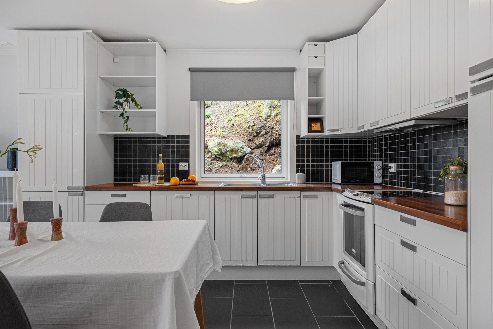 Stilrent og funksjonelt kjøkken med integrerte hvitevarer og god benkeplass. Galleribilde