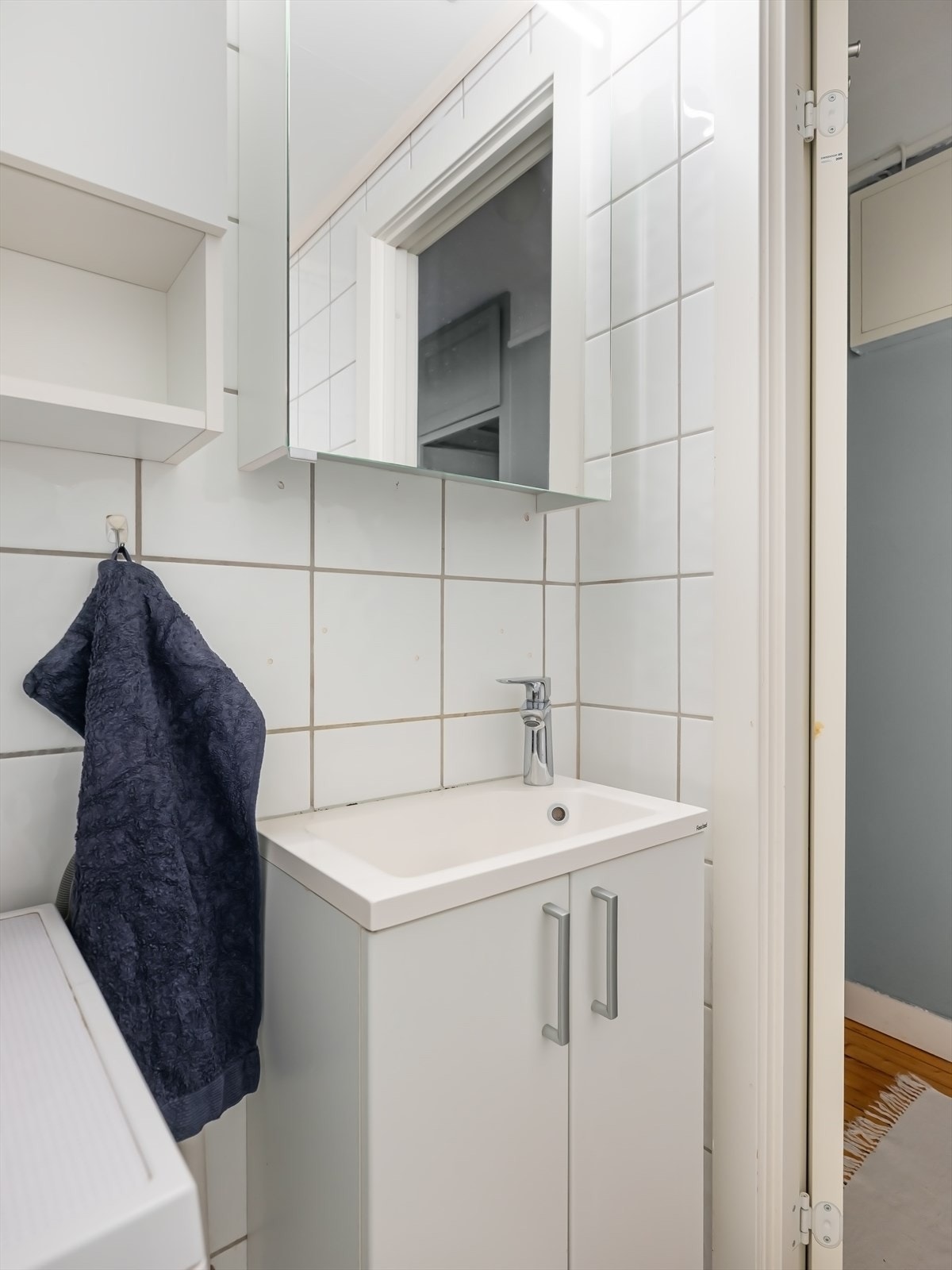 Badet er utstyrt med dusjhjørne med innfellbar dusjdør med blandebatteri fra Oras, gulvmontert toalett og baderomsinnredning med skap, servant med hvit servant og blandebatteri fra Hansgrohe. Galleribilde
