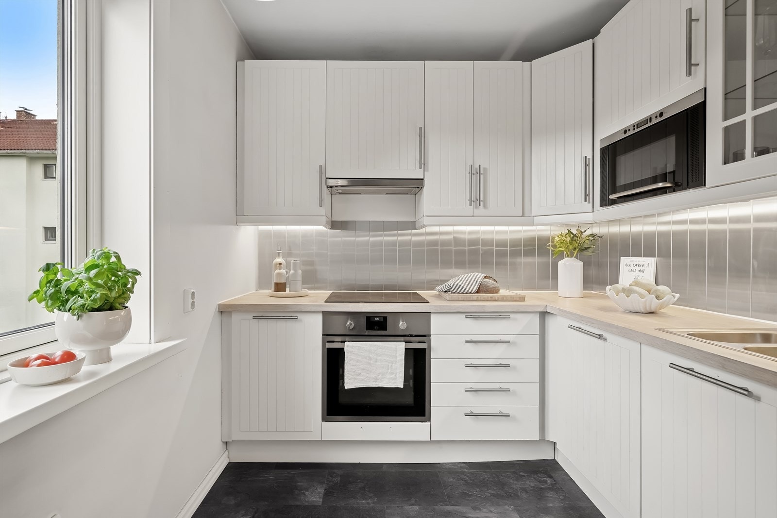 Stilrent kjøkken med moderne fronter og integrerte hvitevarer. Galleribilde