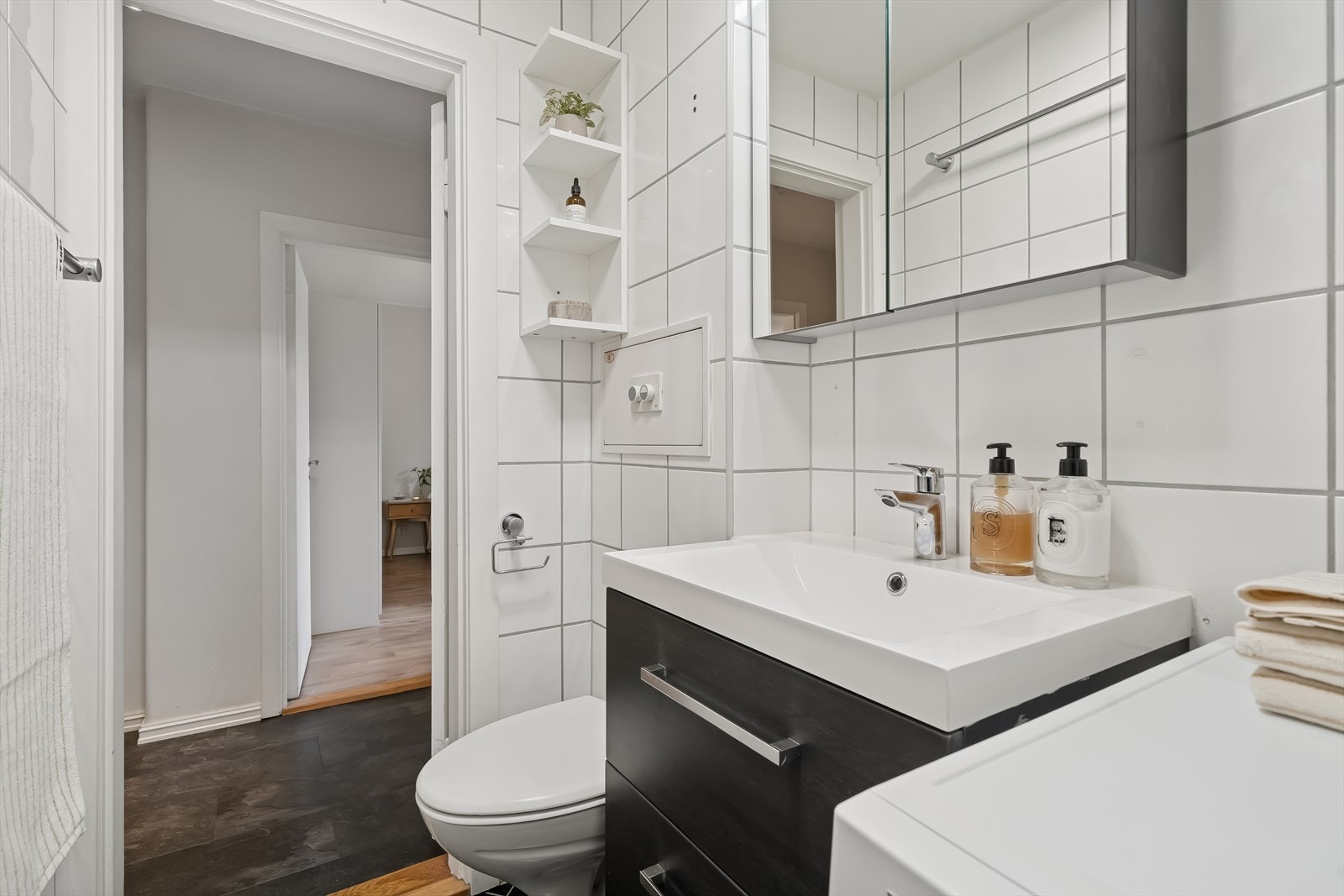 Delikat baderom med fliser på gulv og vegger, og opplegg for vaskemaskin. Galleribilde