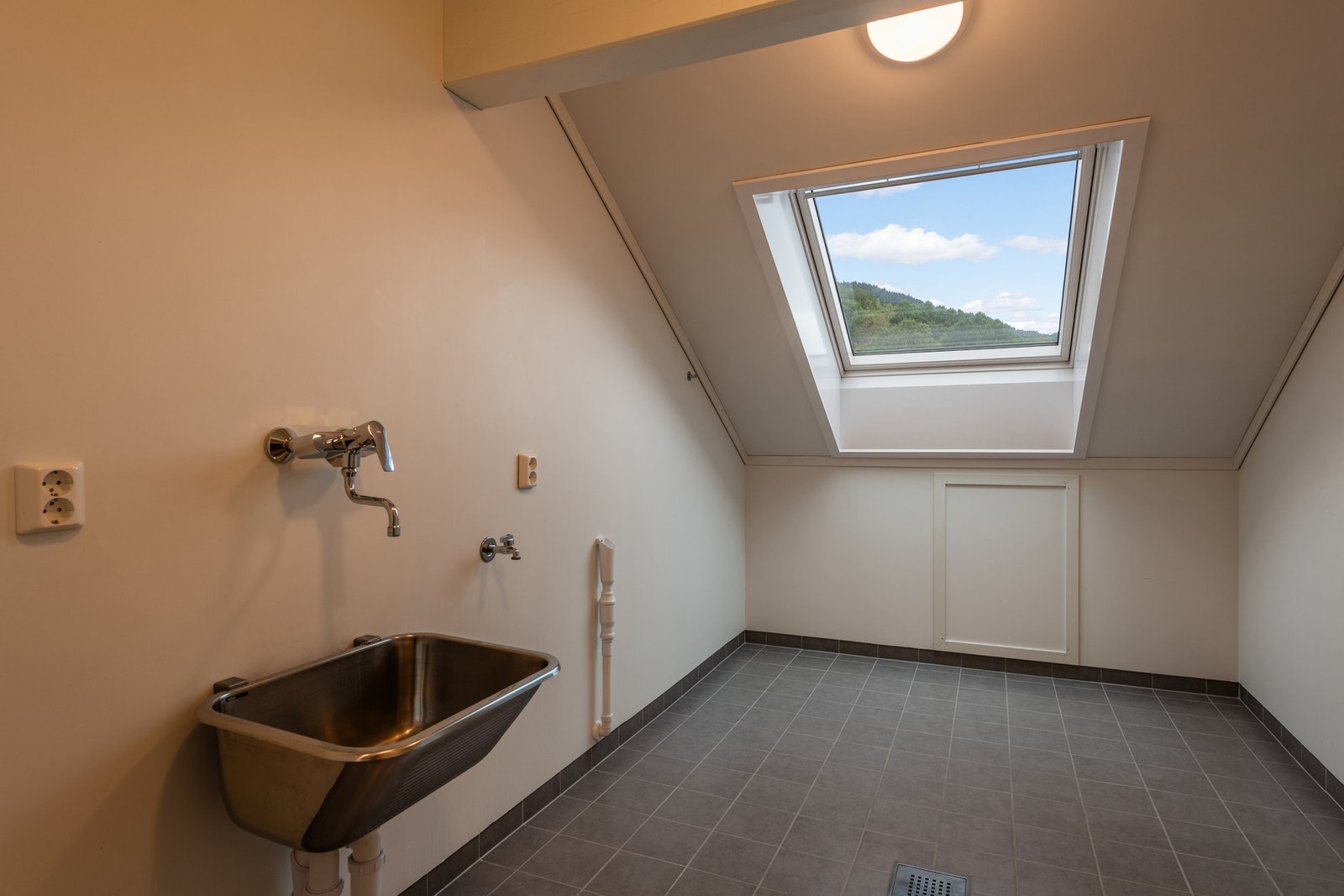 Romslig vaskerom med opplegg for vaskemaskin Galleribilde