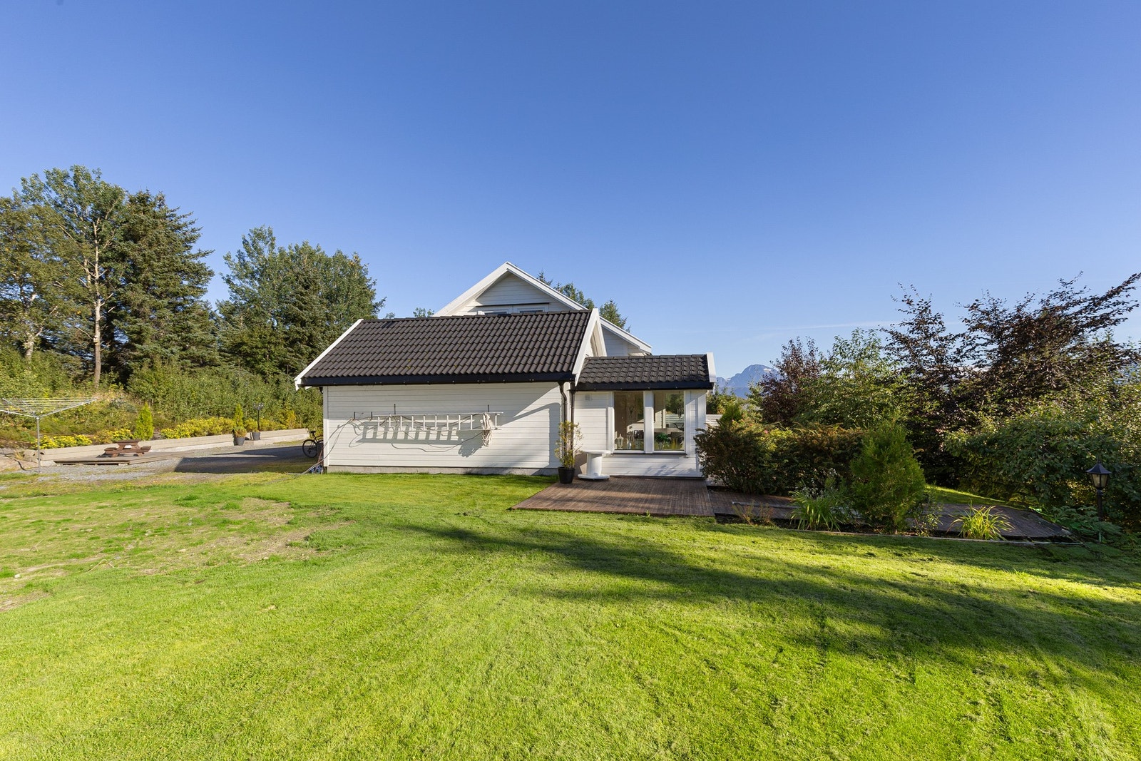 Tomten måler totalt ca. 4,1 mål - og er flott opparbeidet med både terrasse, plen, planter og prydbusker. Galleribilde