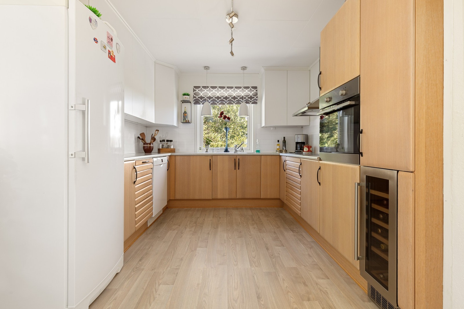 Moderne og stilrent kjøkken med nye takhøye overskap. Benkeplate i laminat. Galleribilde