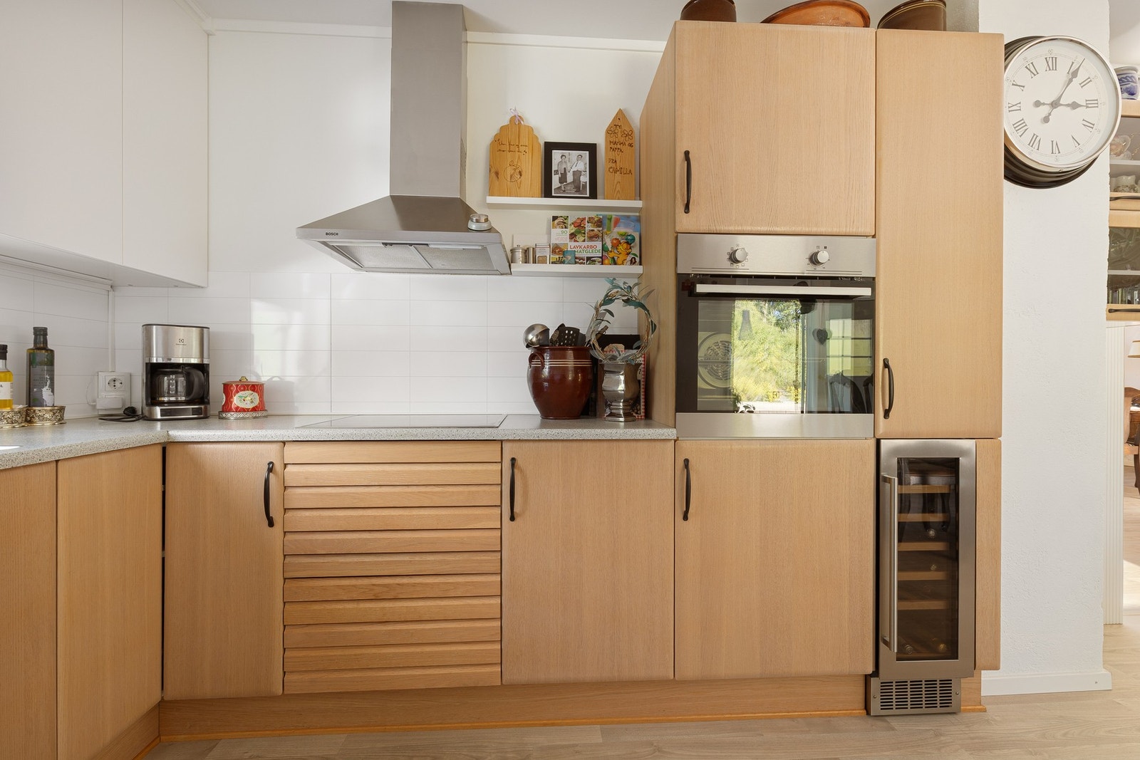 Kjøkkenet har integrerte hvitevarer som oppvaskmaskin, kjøleskap, vinskap, stekeovn og platetopp. Galleribilde