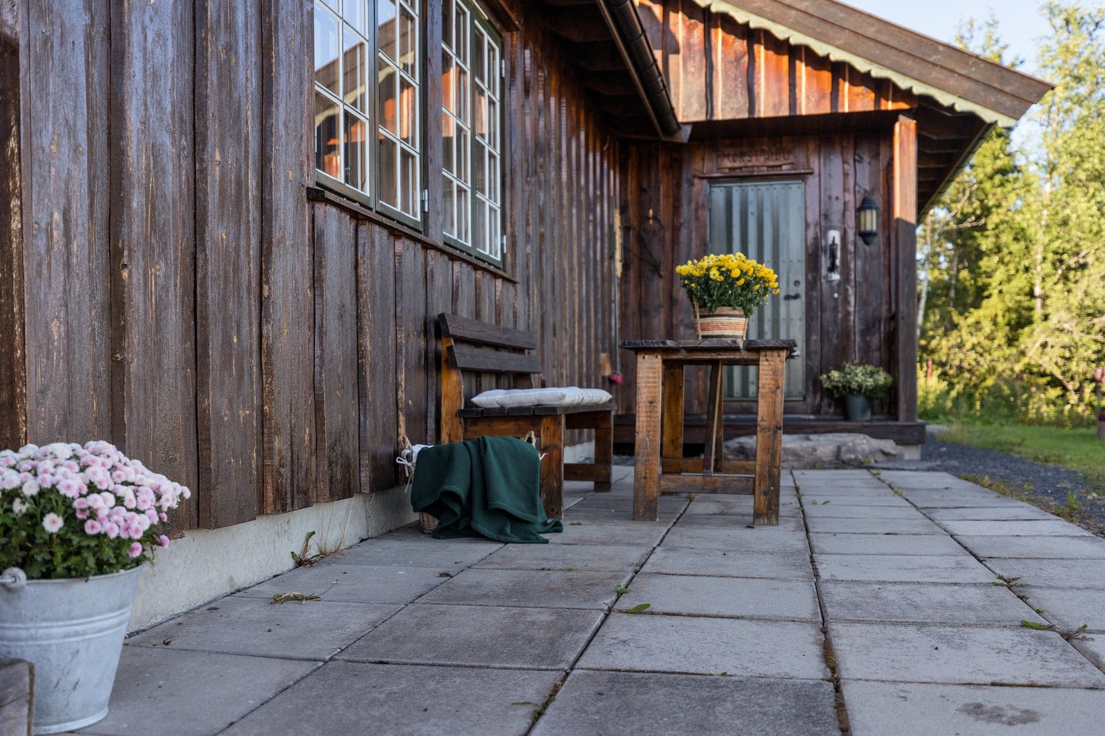 Inngangspartiet har et innbydende, steinbelagt område med plass til en sittegruppe Galleribilde