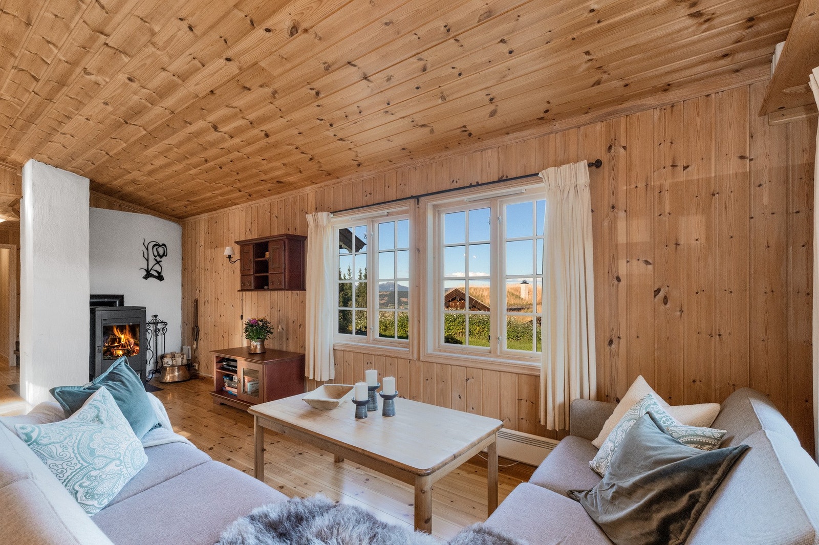 Man kan sitte i sofagruppen og nyte utsynet gjennom vinduene Galleribilde