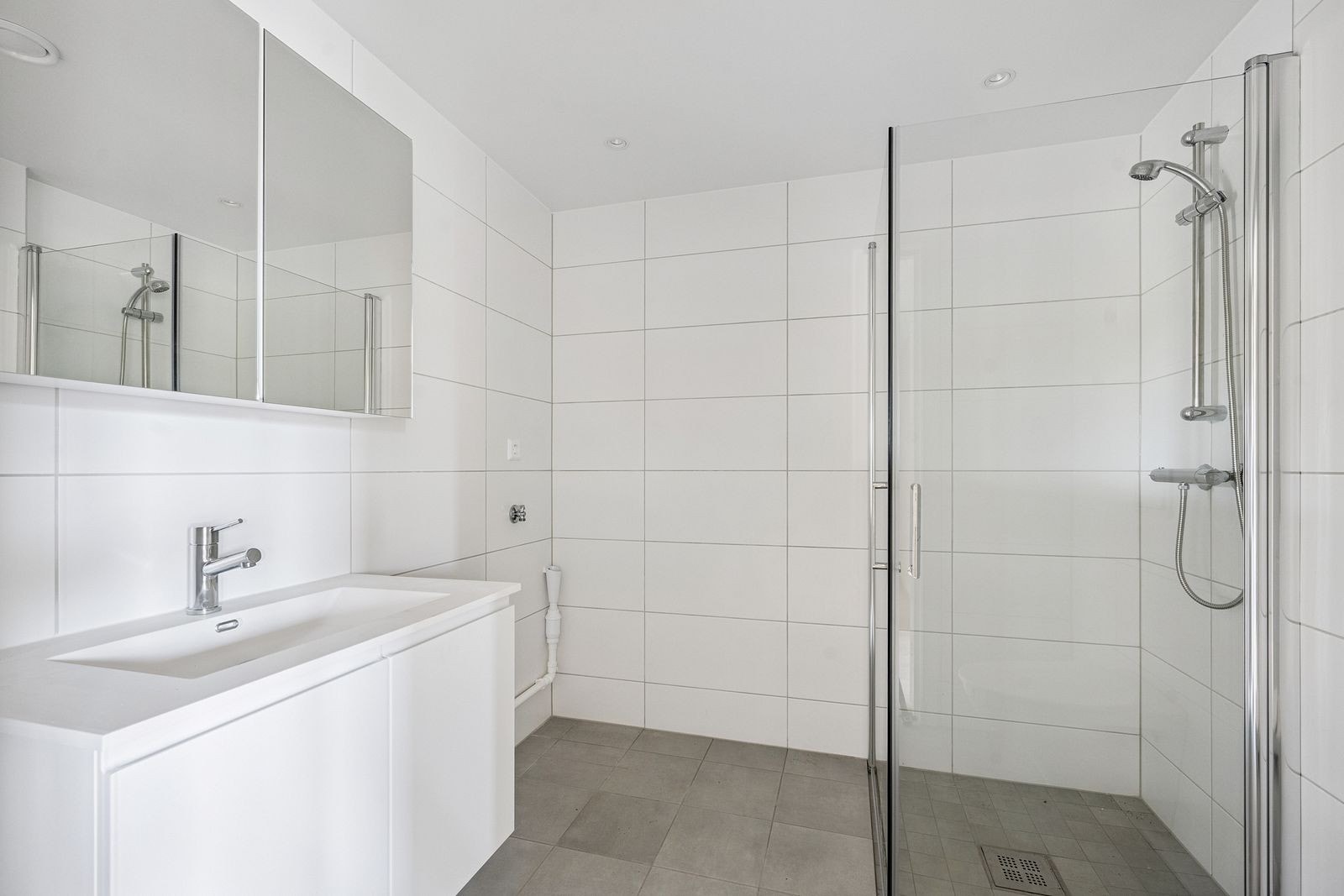 Flislagt bad med opplegg for vaskemaskin og gode oppbevaringsmuligheter Galleribilde