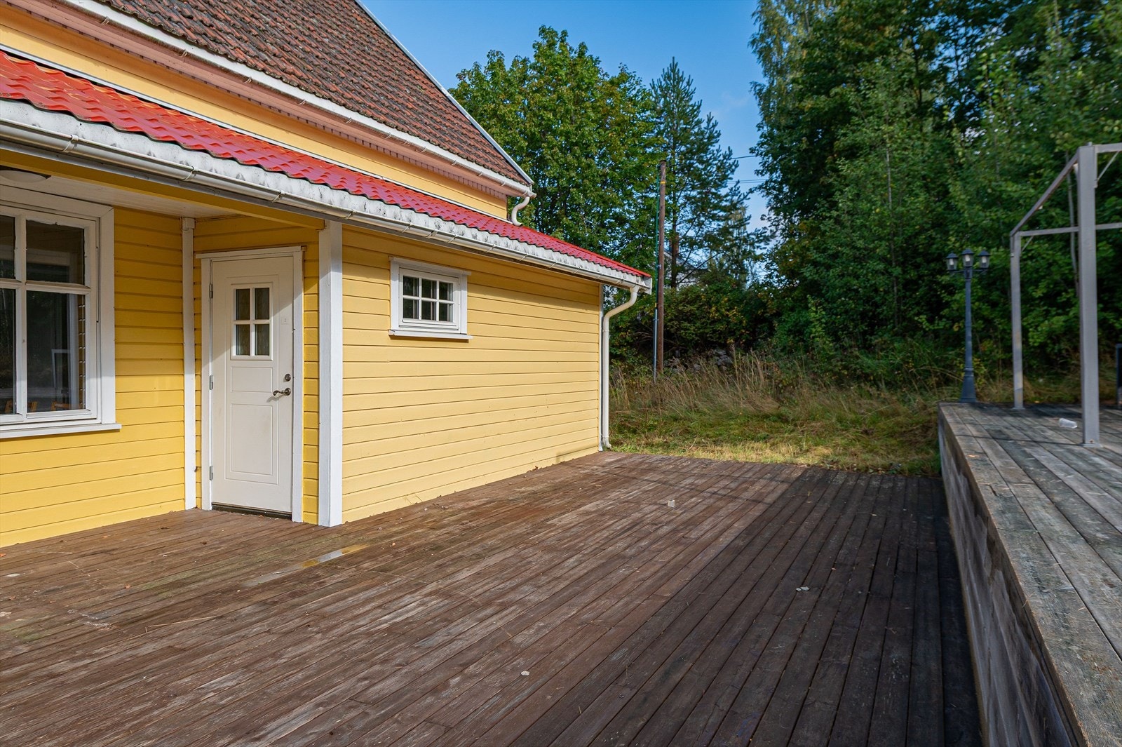 Overbygd inngangsparti med stor terrasse. Galleribilde