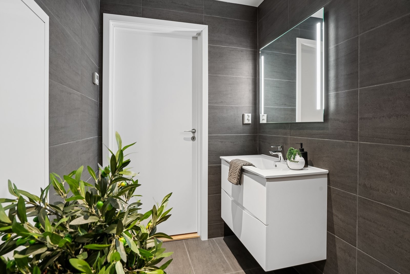 Det er er innredet med vegghengt klosett, dusj med innfellbare vegger, servant med speil over. Galleribilde