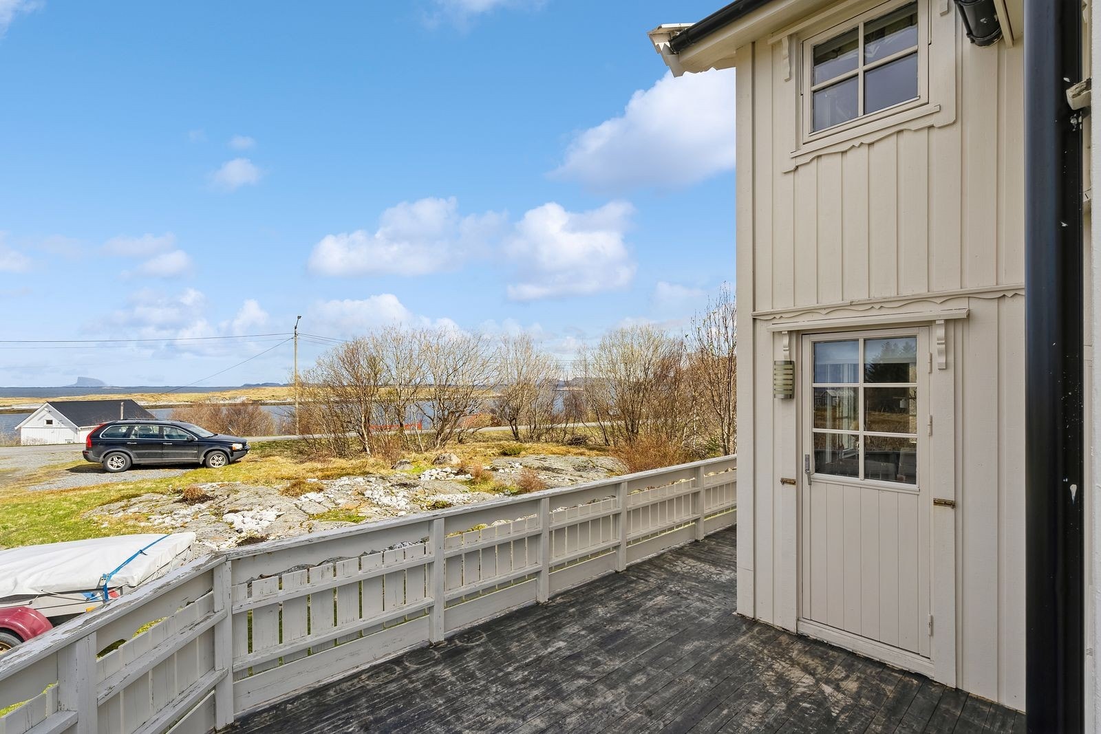 Her ser man litt av hagearealet fremfor boligen og parkeringsplassen. Lovundfjellet kan også skimtes ute i horisonten. Galleribilde