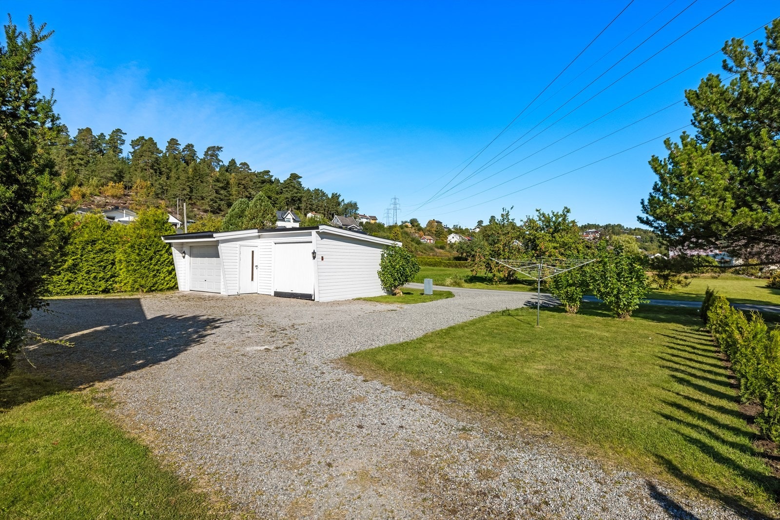Parkering i stor gårdsplass eller i garasje. Vedskjul/bod i forbindelse med garasjen. Galleribilde
