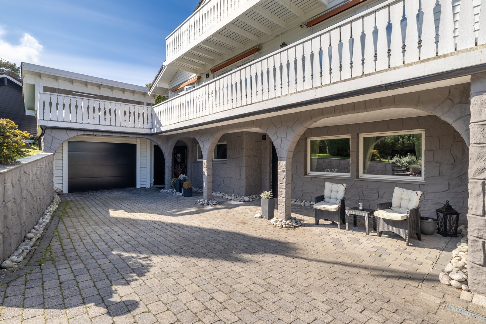 Eneboligen har et pent, overbygd inngangsparti med steinbelagt adkomst og lun velkomstterrasse. Galleribilde