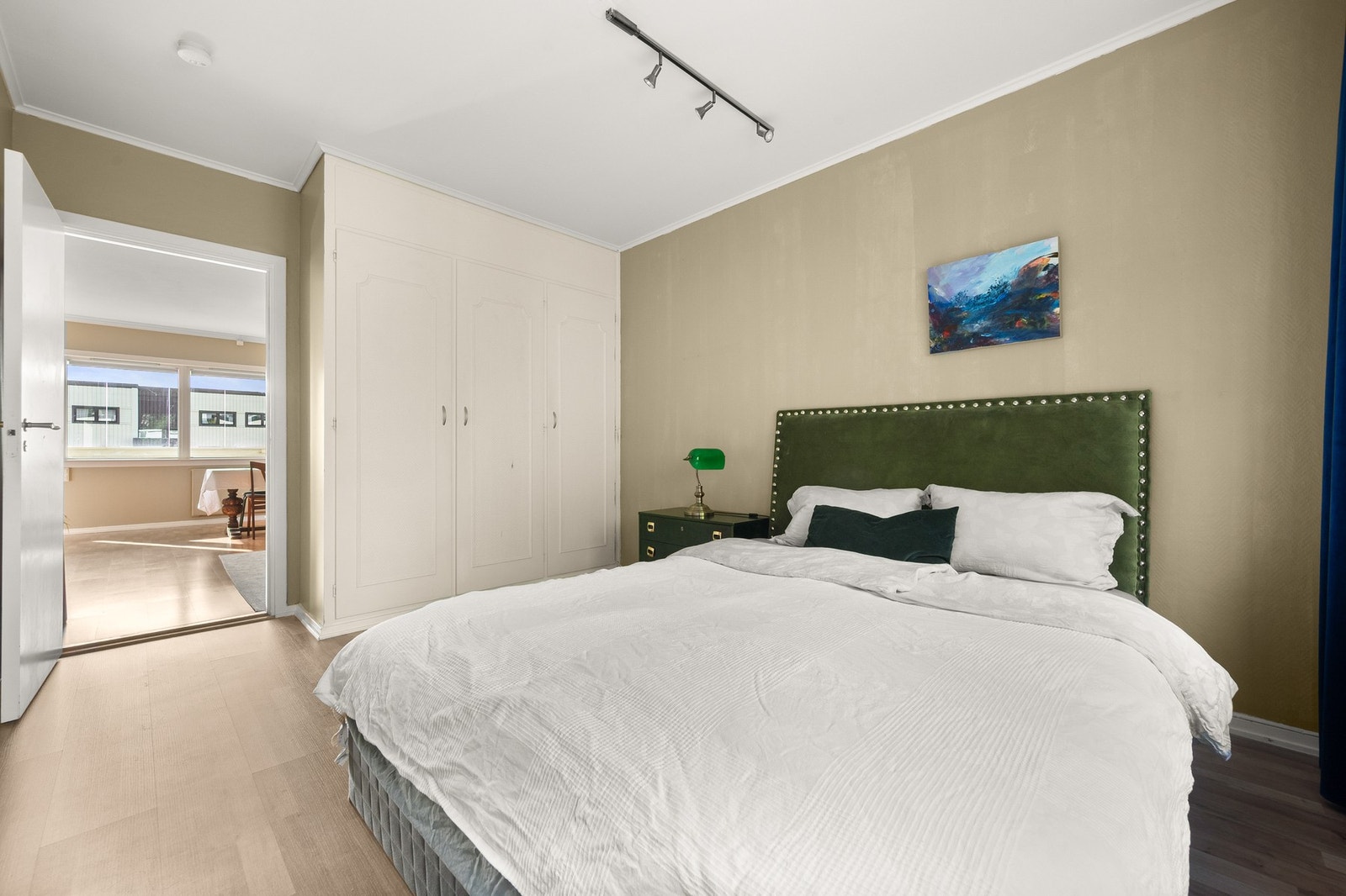 Hovedsoverommet har parkett på gulvet, jordtone farget vegger og hvitmalt himling. Galleribilde