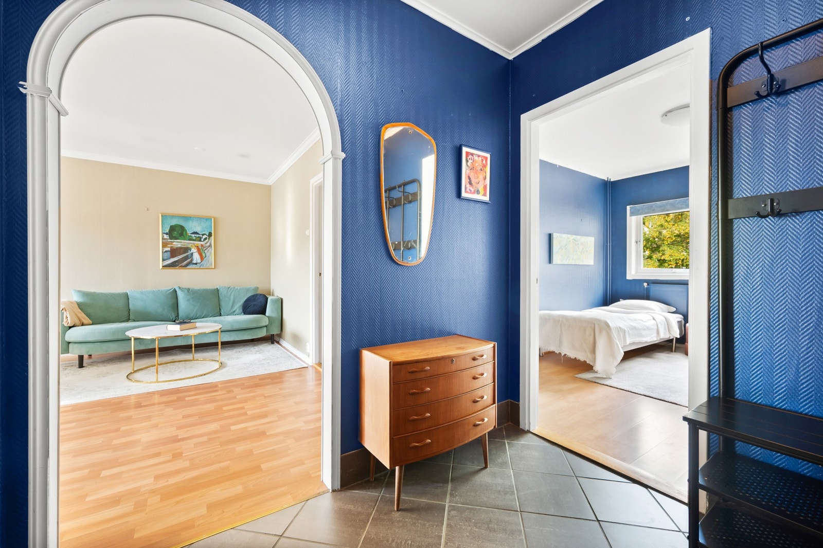 Velkommen inn i entréen. Her er det mørke fliser på gulvet, blåmalte vegger og hvitmalt himling. Galleribilde