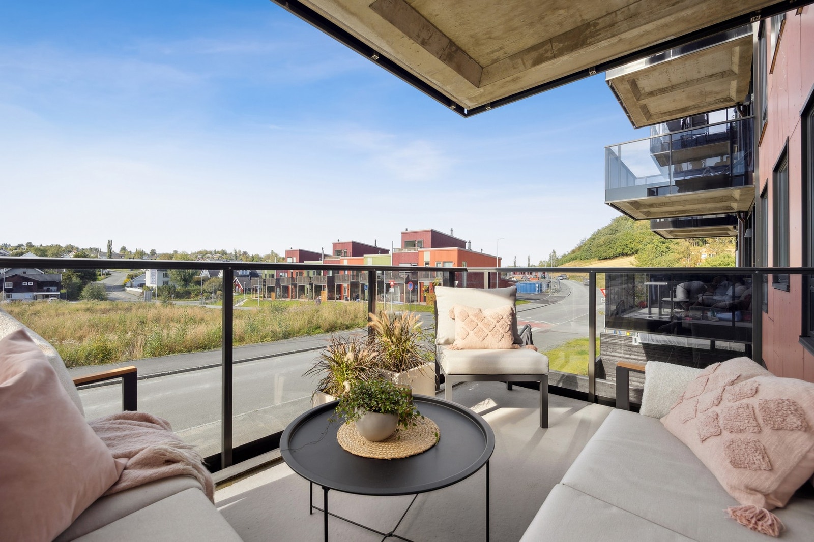 Fra balkongen har man utsikt over nærliggende bolig- og naturområder. Galleribilde