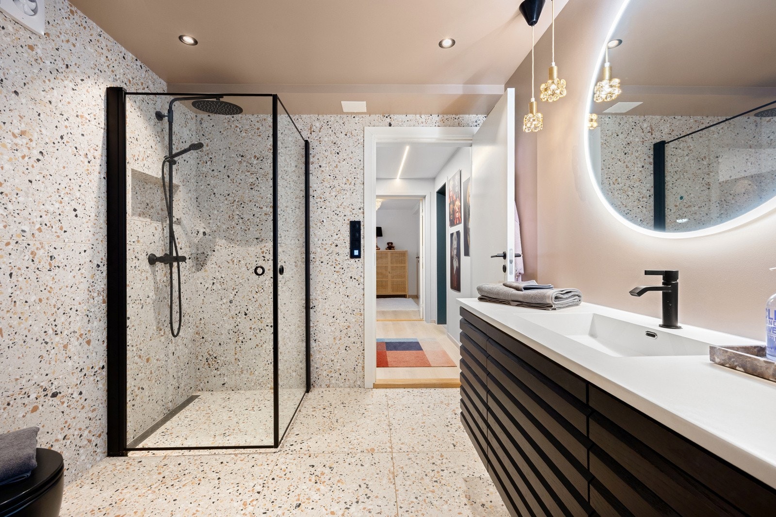 Badet i kjelleren er fra 2021, lekkert innredet med sorte detaljer, regnfallsdusj og terrazzomønstrede fliser. Galleribilde