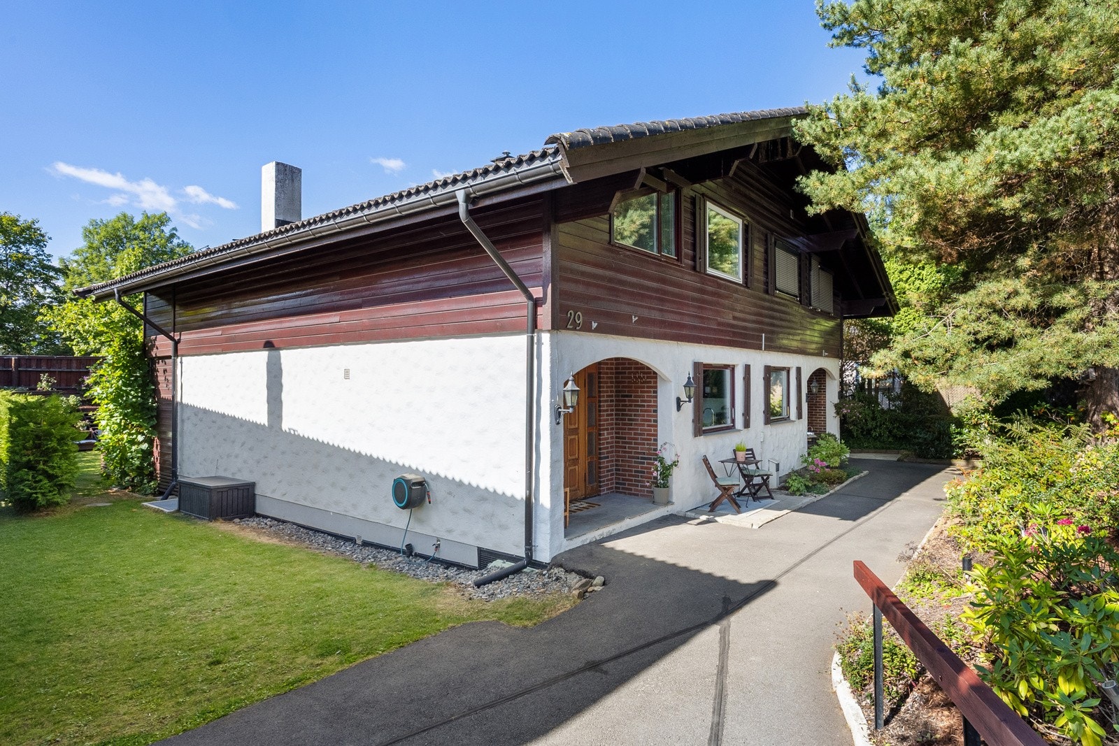Boligen har adkomst fra asfaltert gangvei til et buet, overbygd inngangsparti. Galleribilde
