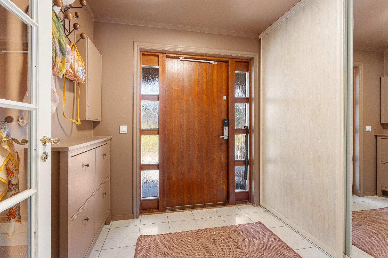 Velkommen inn i en pen og velholdt bolig med gulvfliser, gulvvarme og skyvedørsgarderobe i entreen. Galleribilde