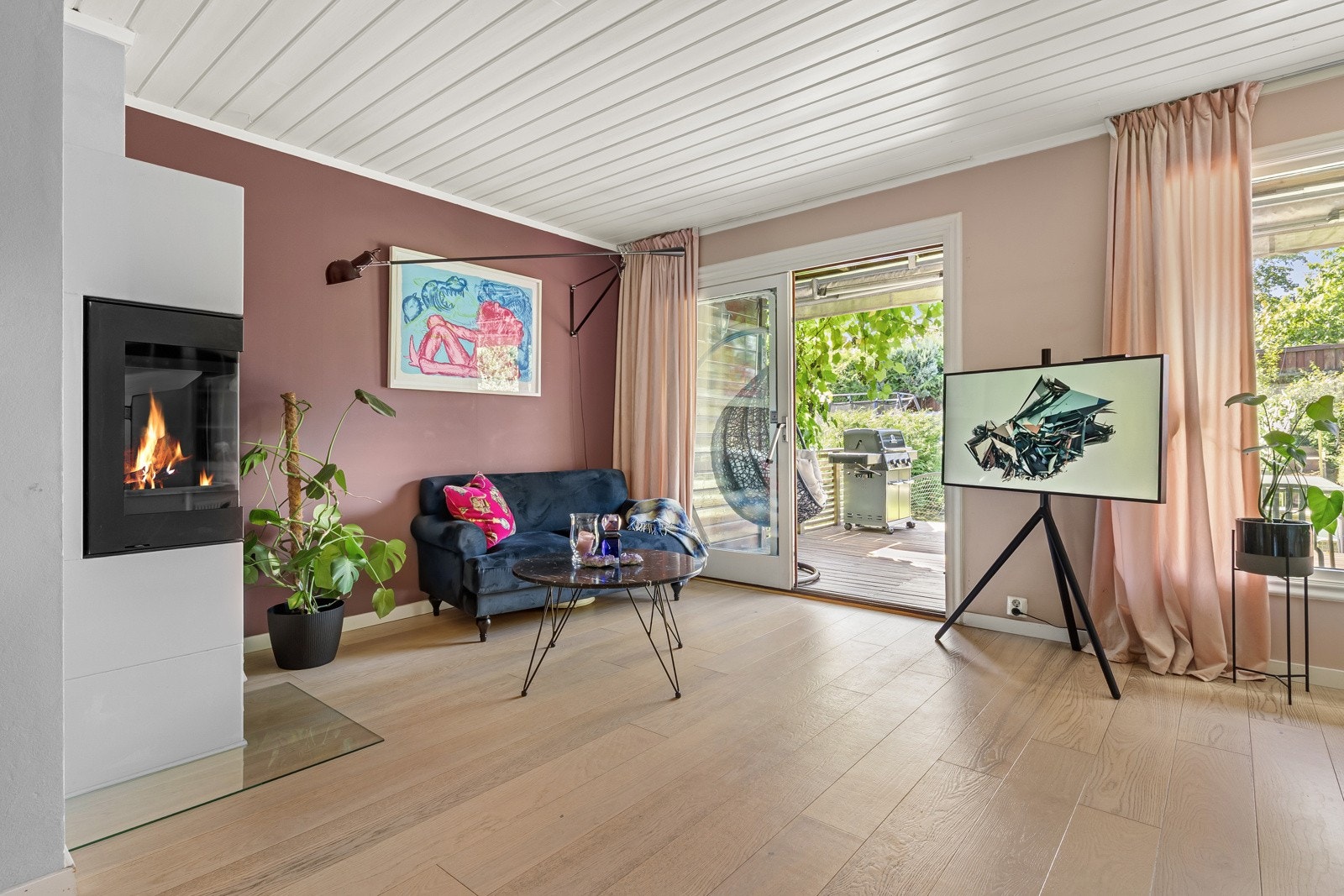 Store vindusflater og skyvedører mot terrassen gir godt med dagslys til det flotte rommet. Galleribilde