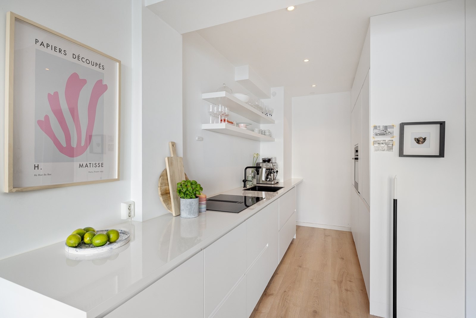 Stilsikker innredning med hvite, glatte fronter og benkeplate i laminat. Galleribilde