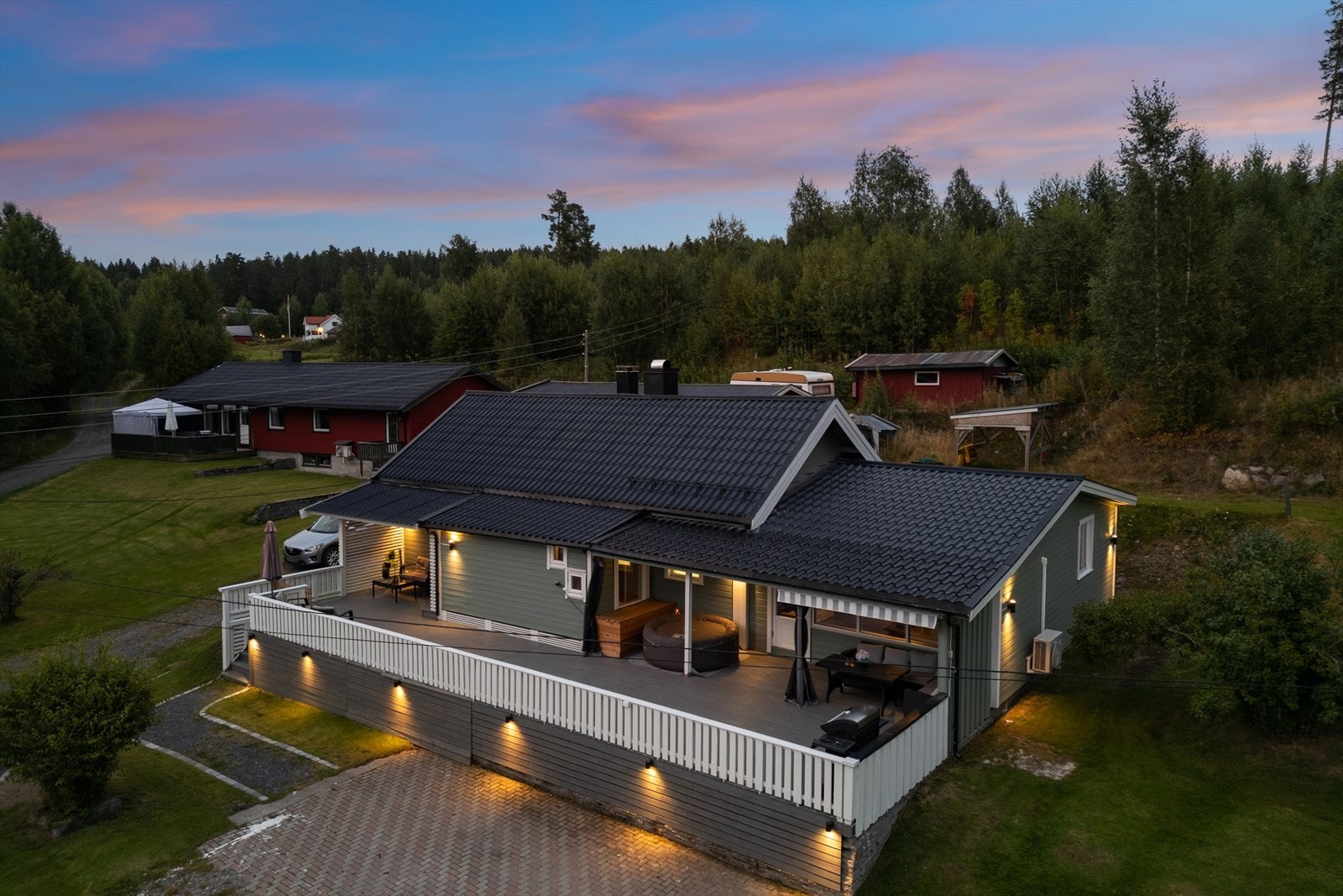 Delikat utebelysning gir eiendommen et innbydende og ekslusivt preg på kveldstid Galleribilde