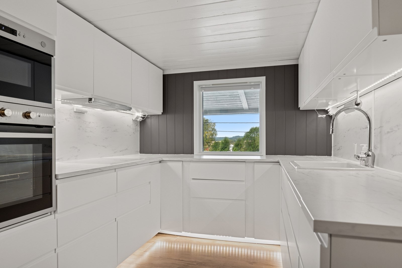 Kjøkkenet har godt med skap- og benkeplass Galleribilde