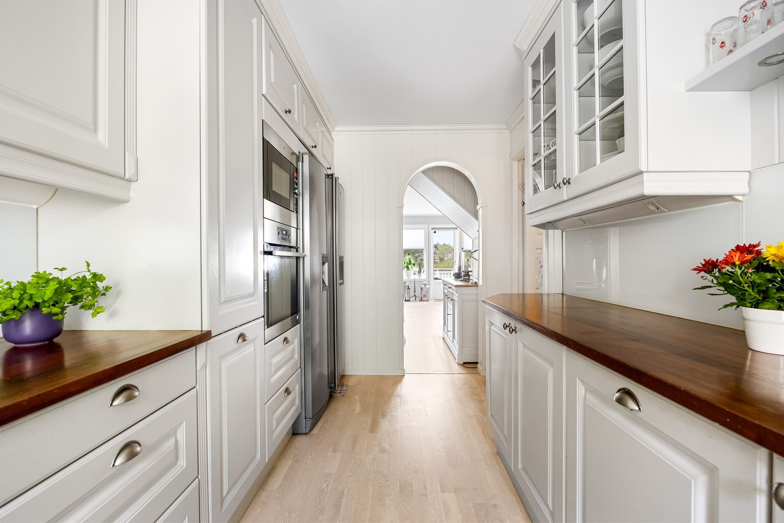 Pen kjøkkeninnredning med profilerte fronter og heltre benkeplater med nedfelt oppvaskkum. Galleribilde