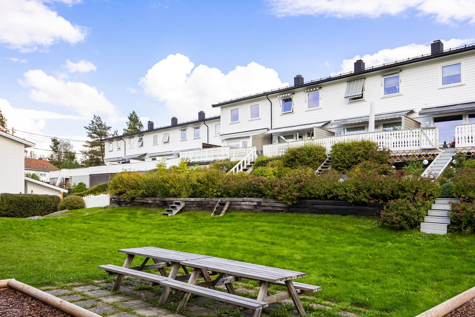 Borettslagets tomt er pent opparbeidet med gressplener og diverse beplantning. Galleribilde